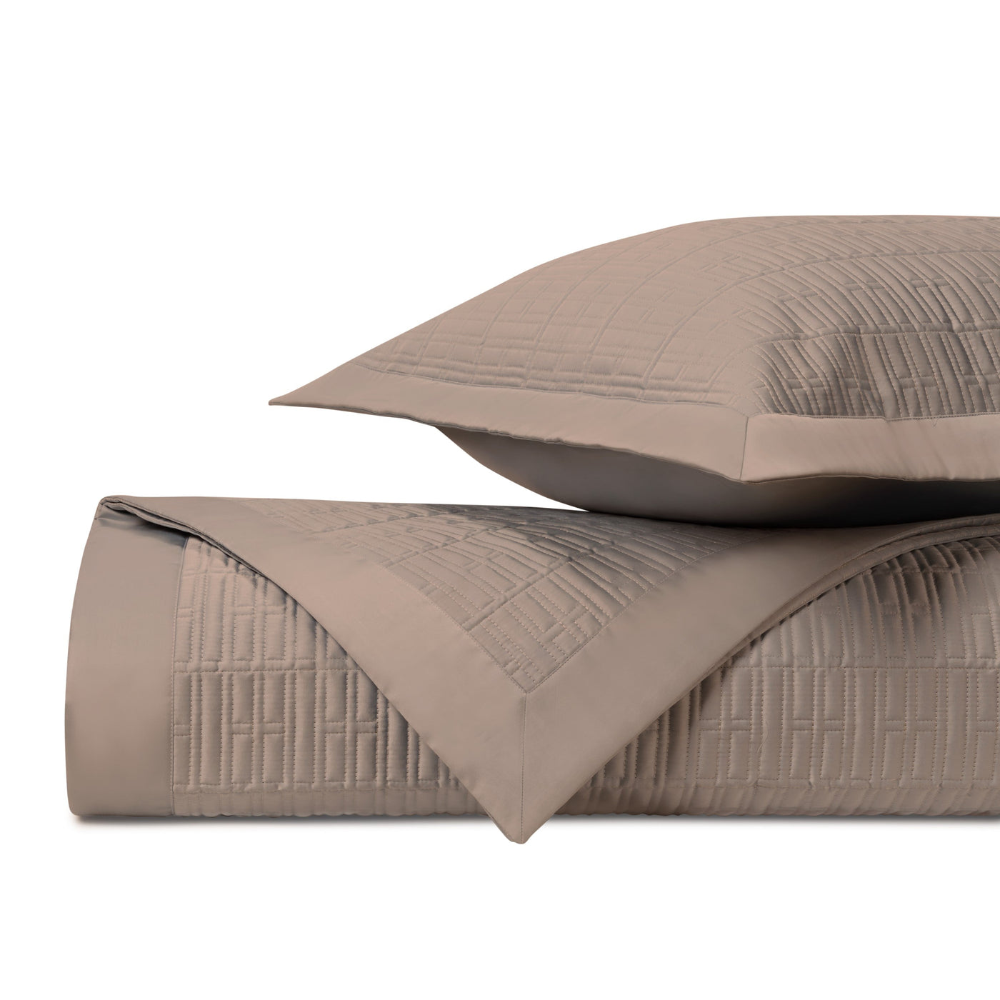 Close-up of Sydney quilted texture in taupe, showing geometric stitching pattern on folded coverlet and sham.