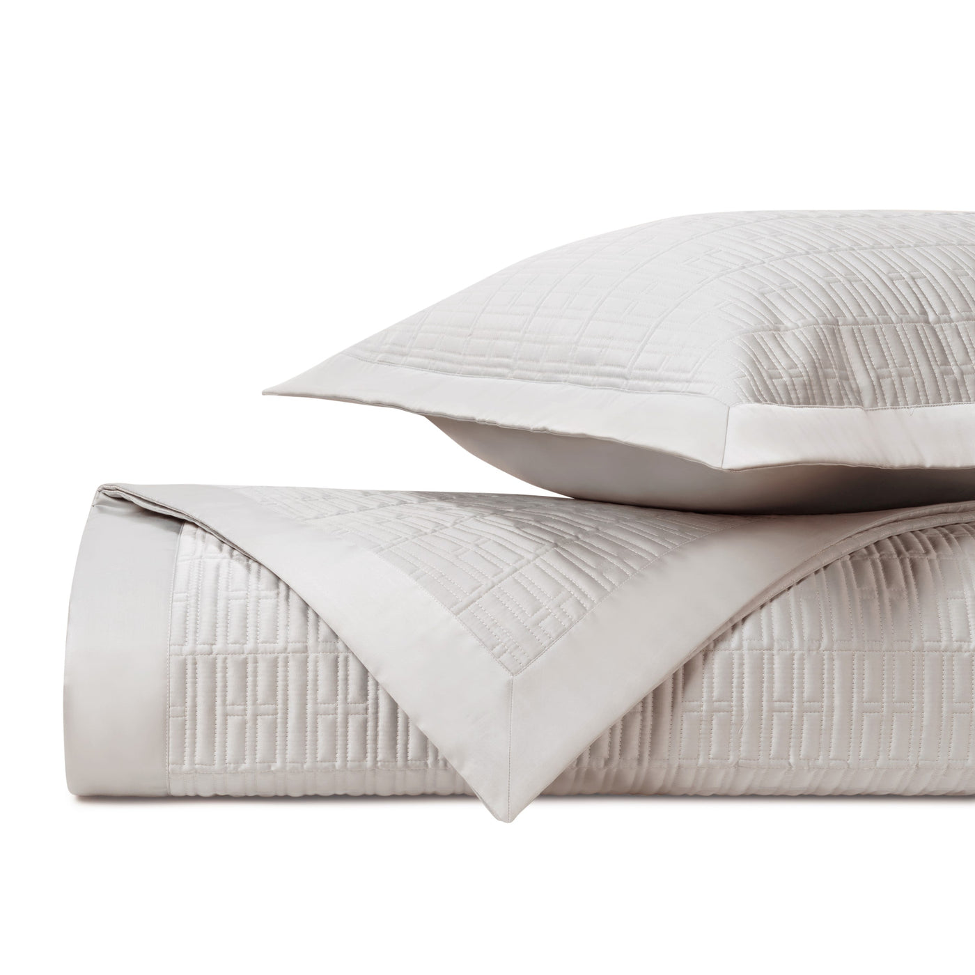Close-up of Sydney quilted coverlet and sham in ivory with geometric stitched pattern.