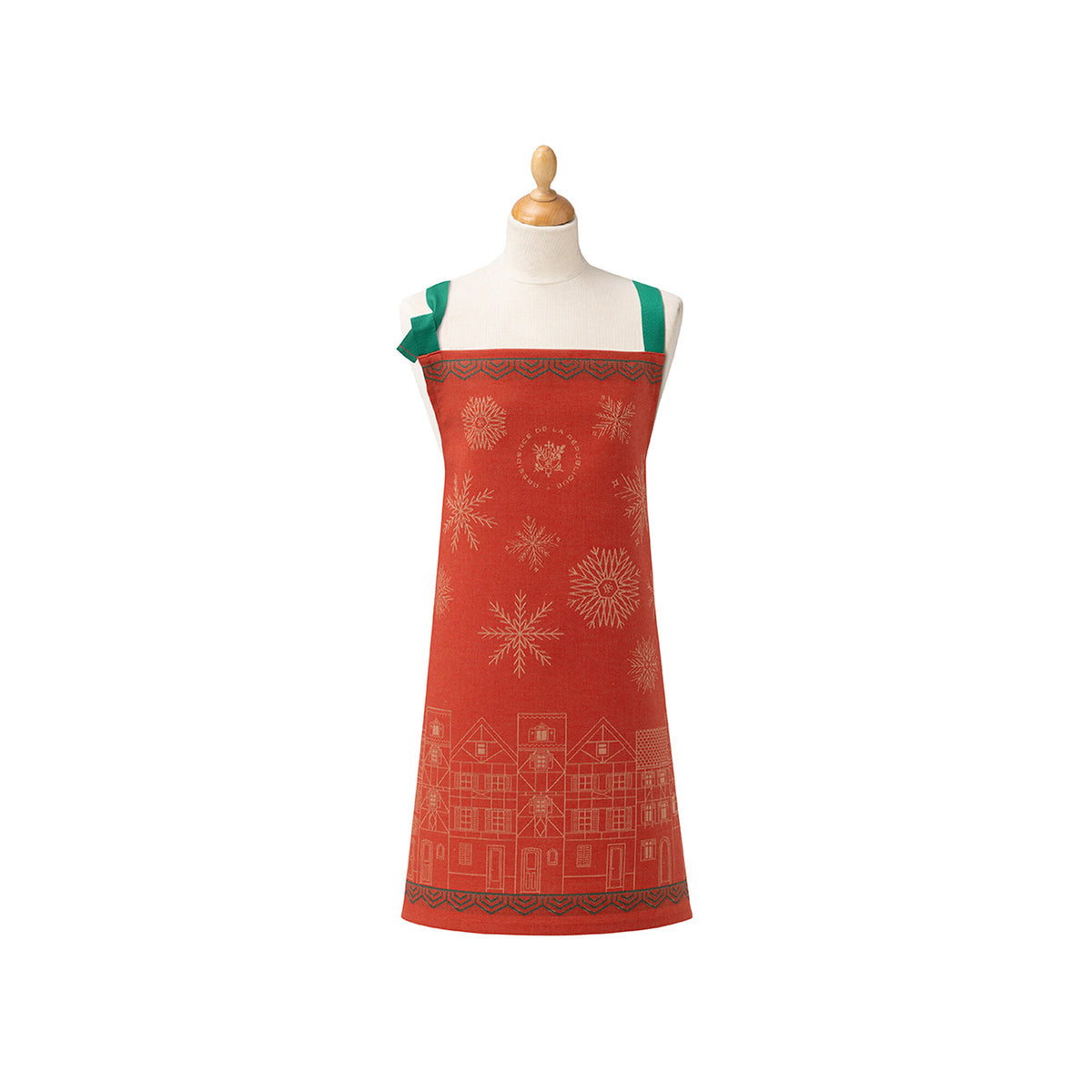 Le Jacquard Français Village de Noël red apron with gold snowflake and village jacquard pattern on mannequin.