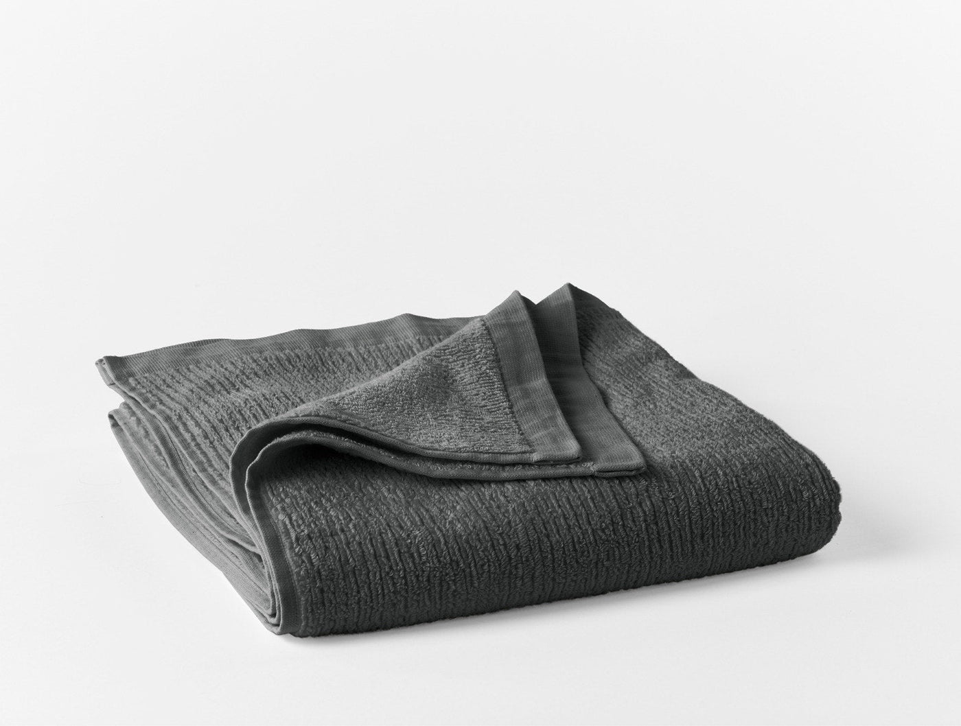 Folded charcoal ribbed wash cloth showing textured weave and smooth reverse side.