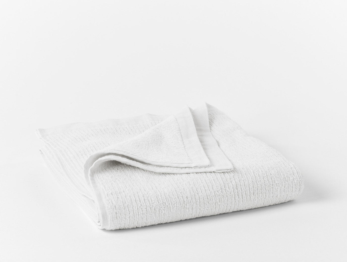 Coyuchi Temescal ribbed hand towel in white, neatly folded to show textured weave.