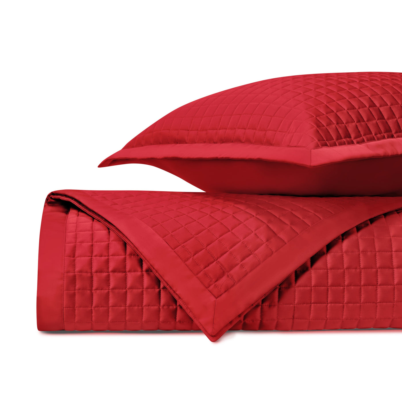 Crimson quilted coverlet and sham with geometric square stitching pattern, folded.