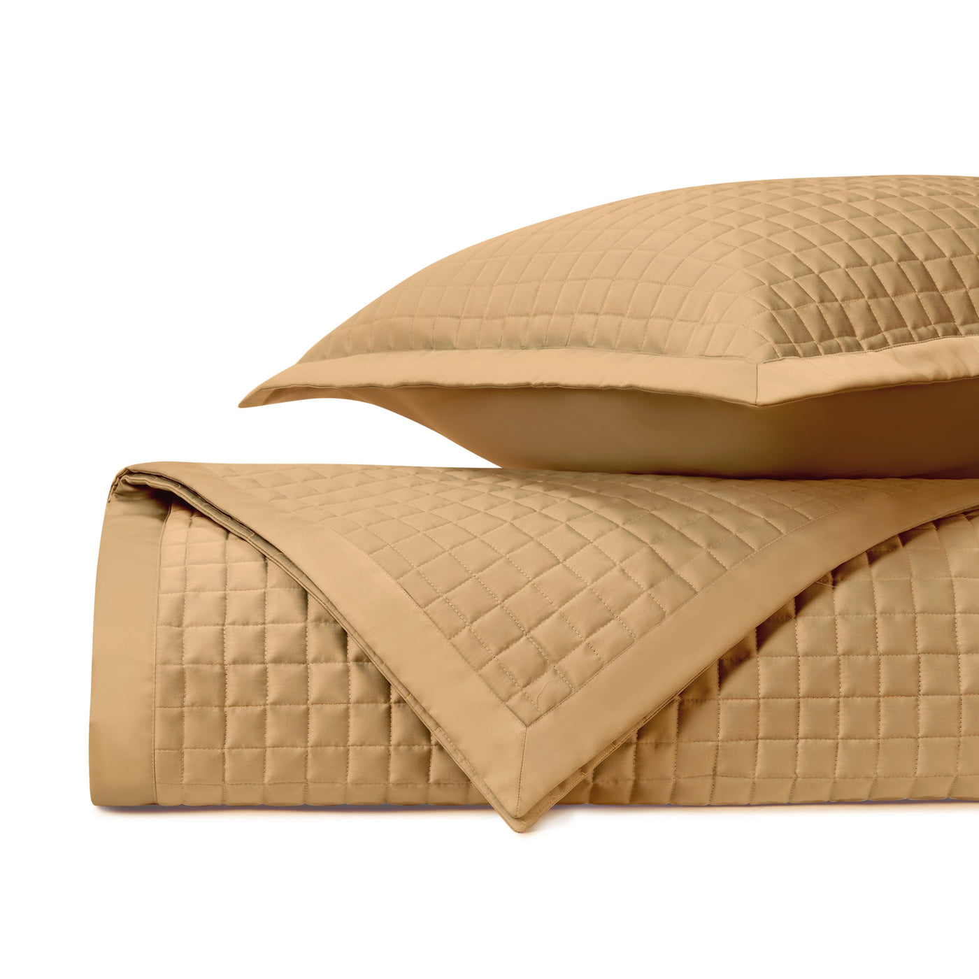 Close-up of honey quilted fabric with geometric square stitching pattern and flat border edge.