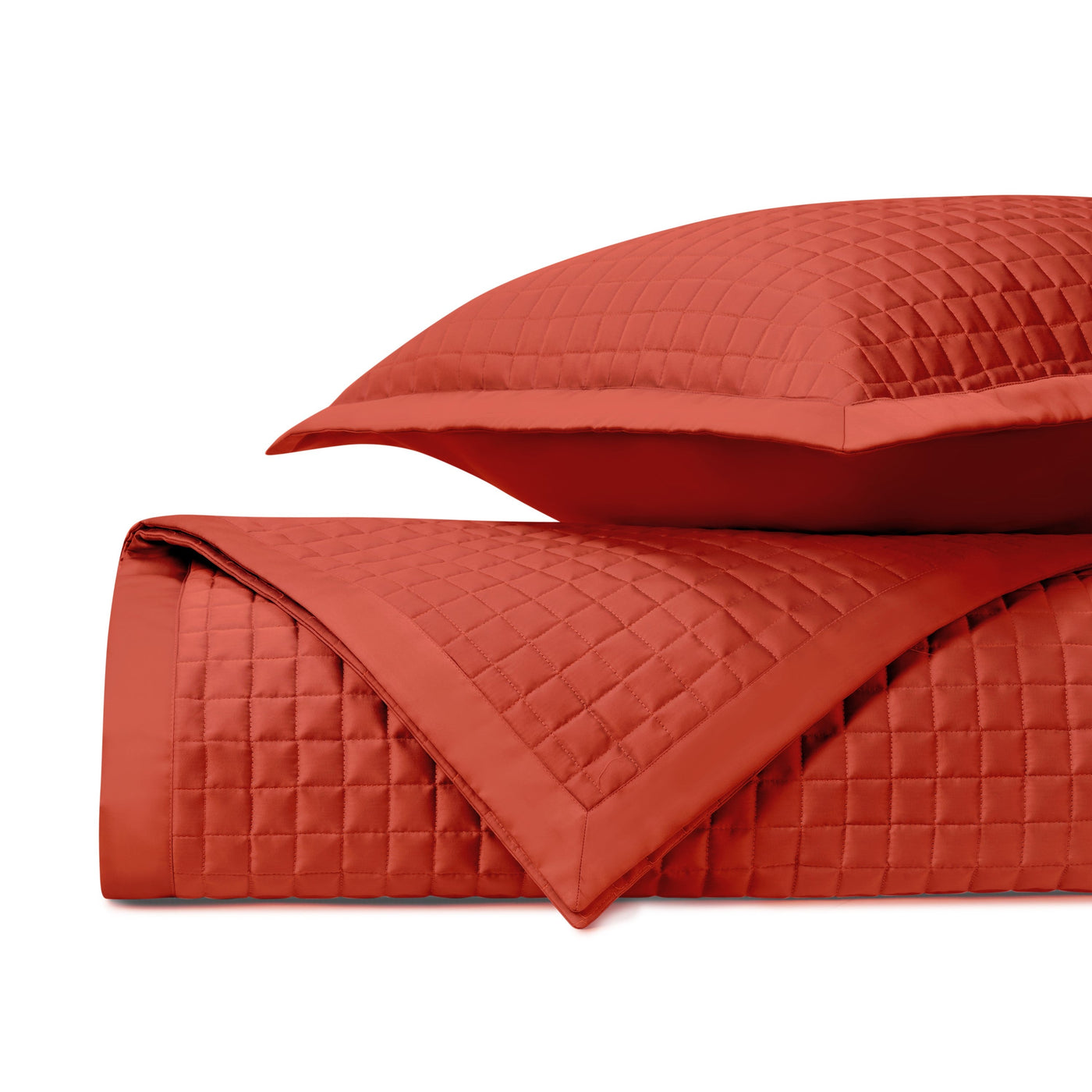 Close-up of Home Treasures Time Square quilted coverlet in tomato red, showing grid stitching detail.
