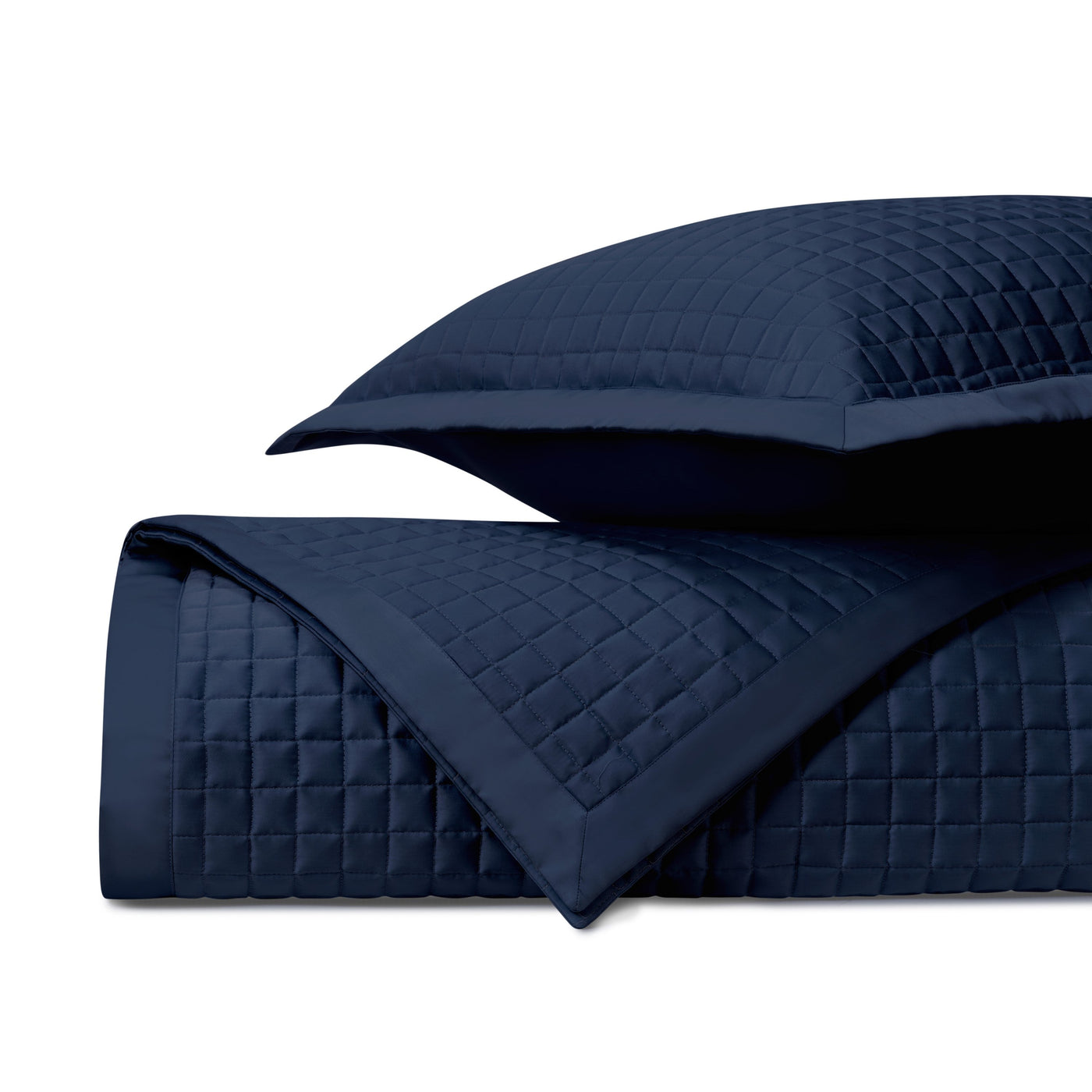 Navy quilted fabric with diamond grid pattern, folded with coordinating sham visible.