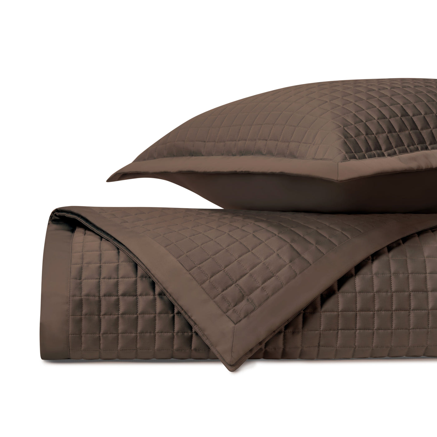 Close-up of chocolate quilted coverlet and sham showing grid-stitched texture and tailored border.