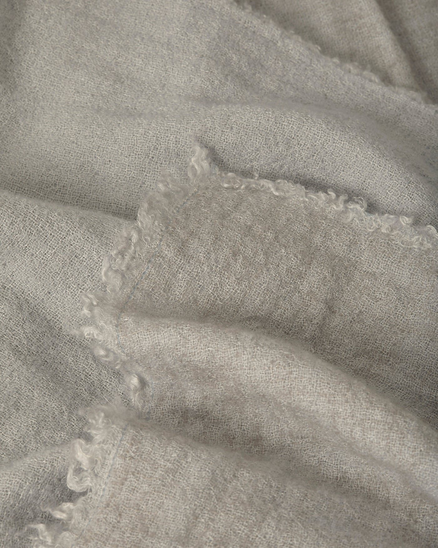Close-up of Society Limonta Tiub throw in dove grey, showing blanket-stitched edge detail.