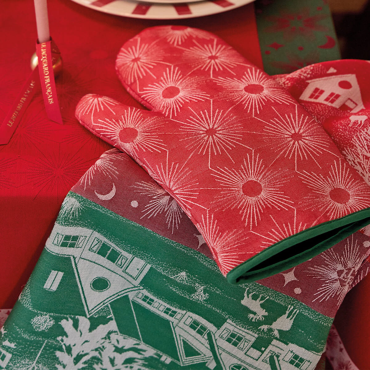 Le Jacquard Français Sous les Étoiles oven mitt in Red with white starburst and house print.