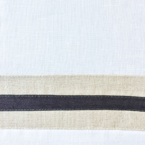Close-up of white linen with natural and charcoal border stripe detail.