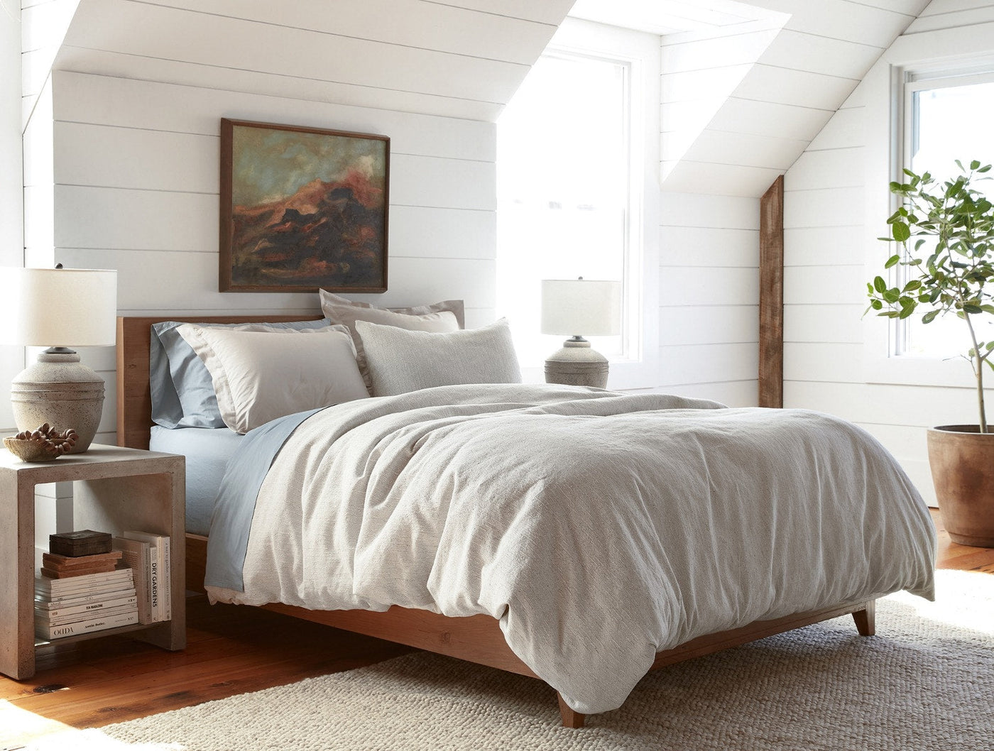 Toro Canyon sham styled on a made bed in a sunlit attic bedroom with sloped white walls.
