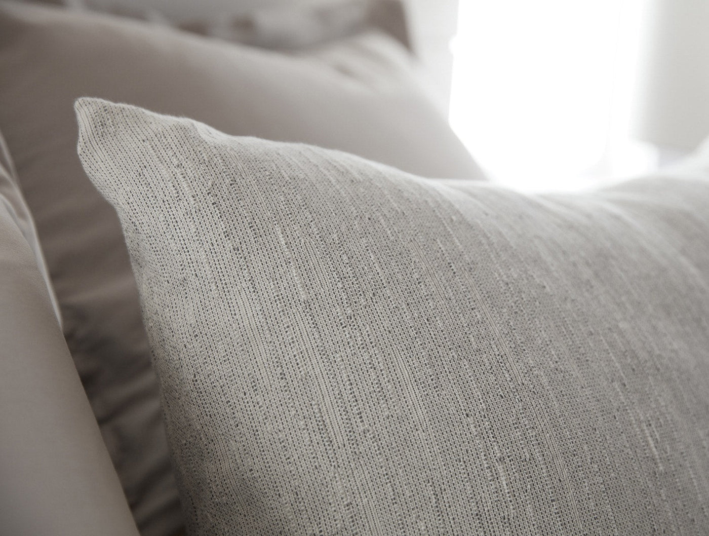 Close-up of Coyuchi Toro Canyon sham's heathered linen weave texture in natural grey.