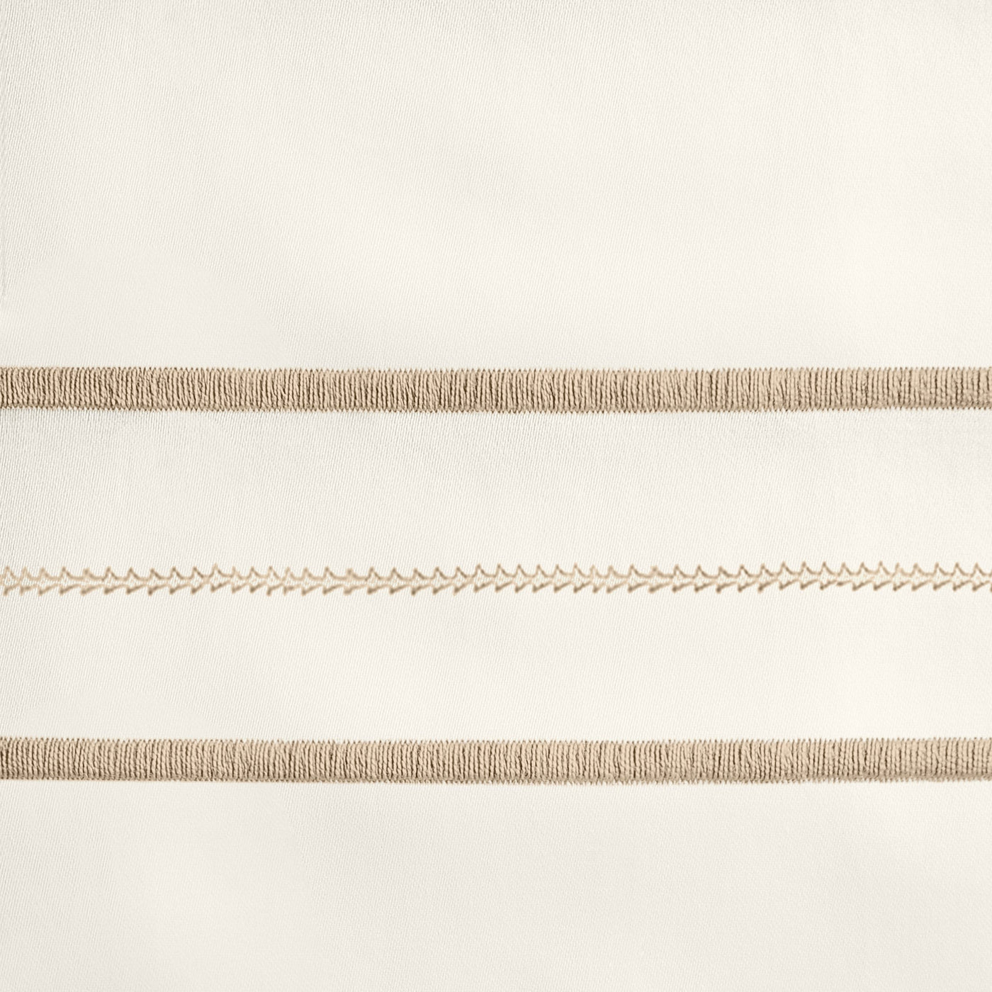 Close-up of champagne embroidered stripe detail on ivory cotton flat sheet.