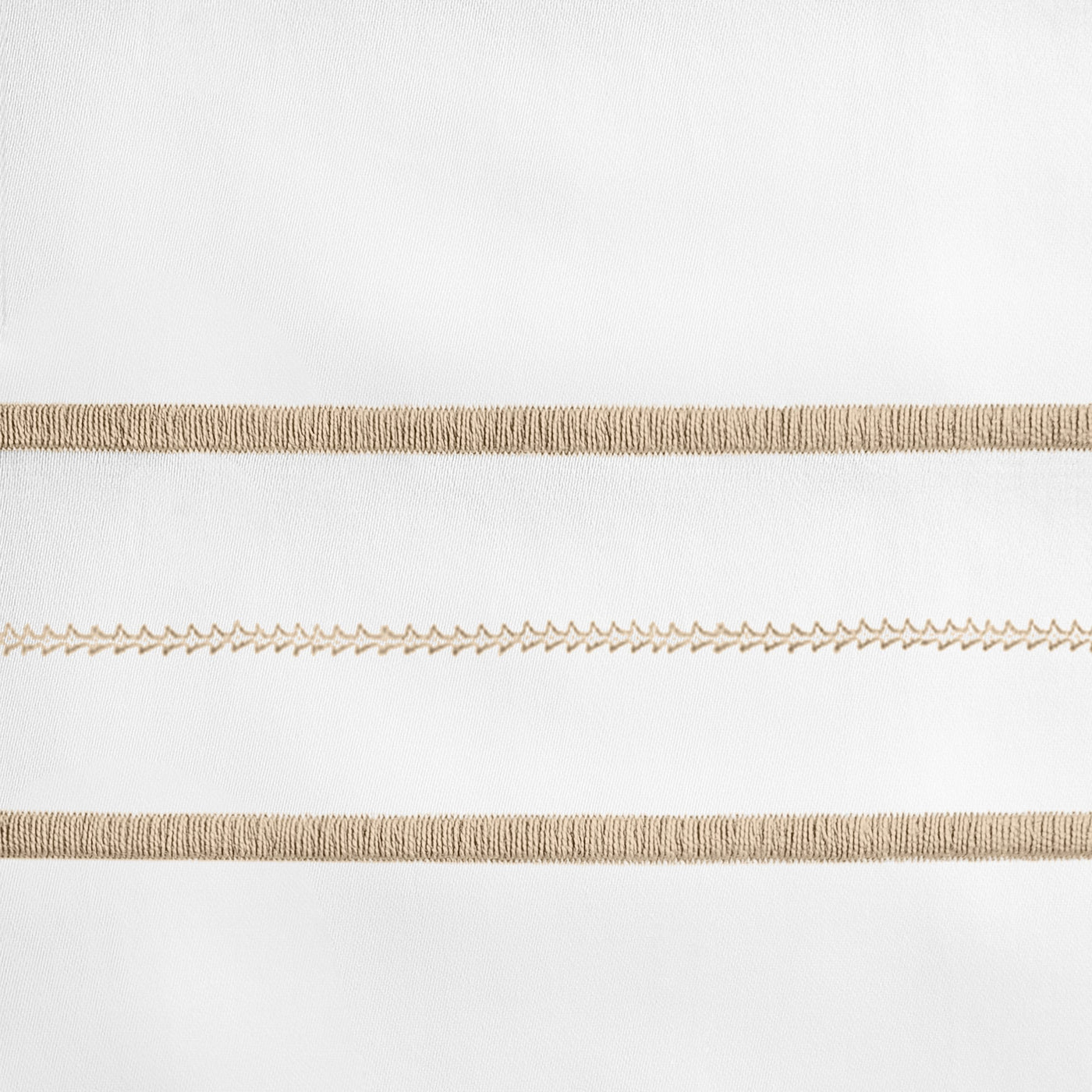 Close-up of champagne embroidered stripe detail on white linen fabric.