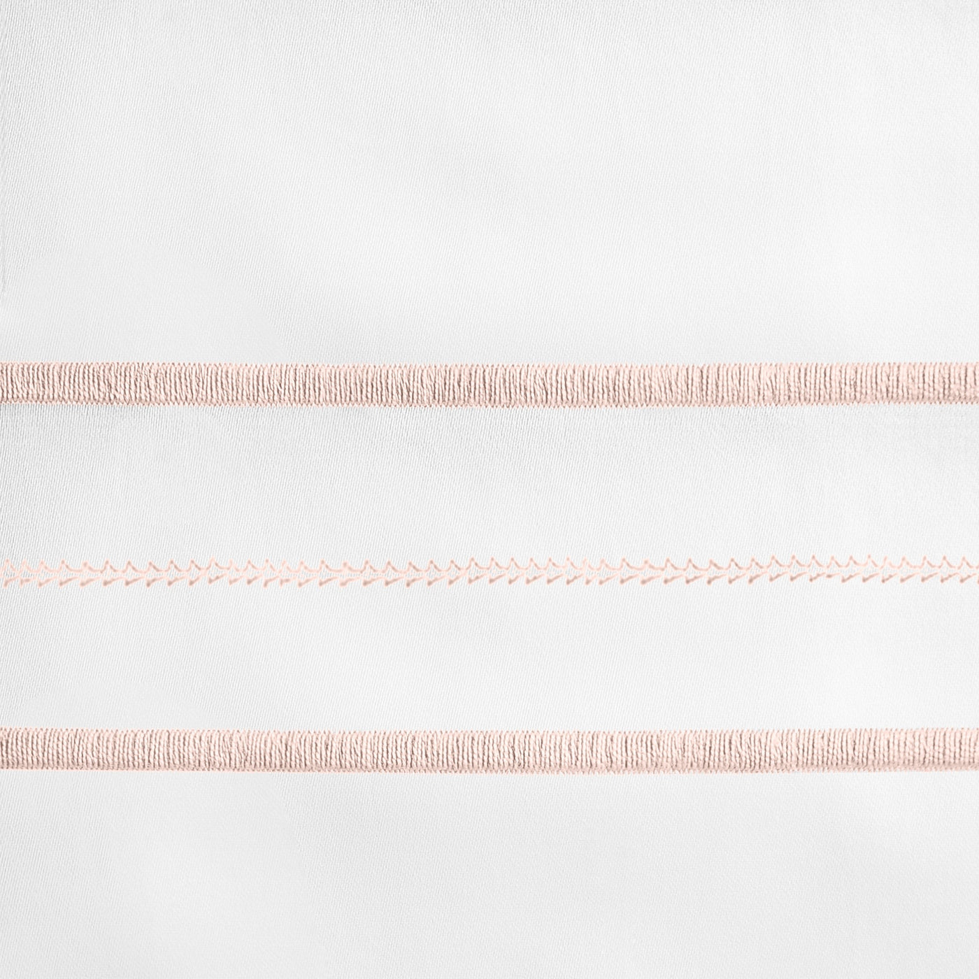 Close-up of blush embroidered stripe detail on white linen, showing textured banding rows.