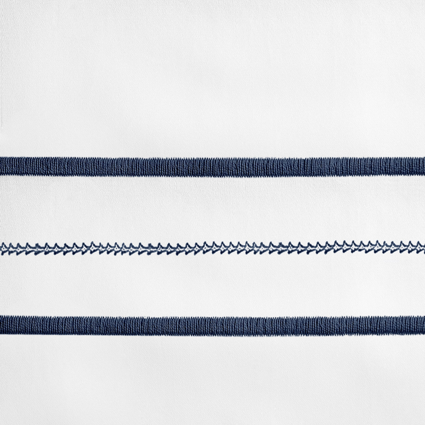 Close-up of navy embroidered stripe detail on white cotton flat sheet.