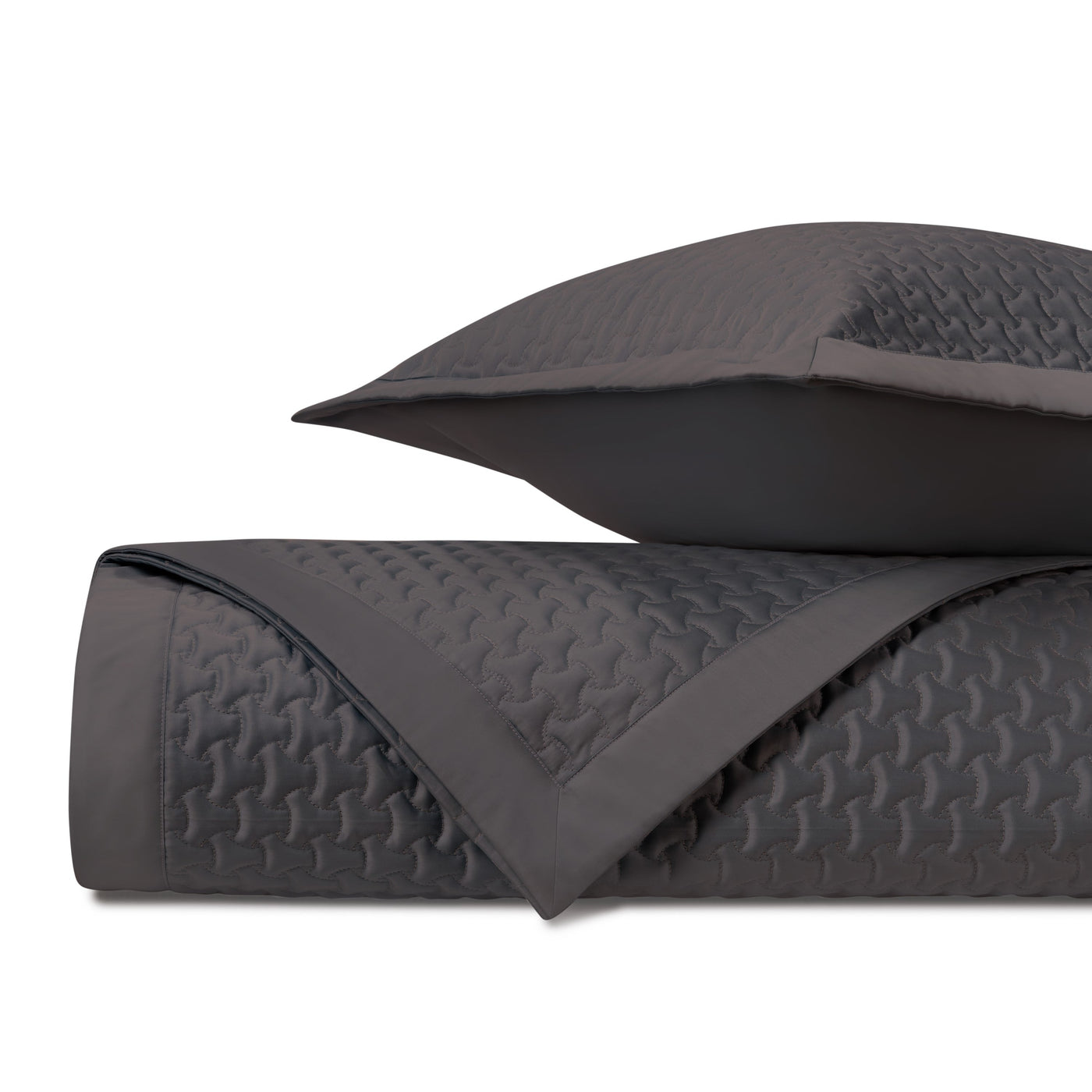 Close-up of charcoal quilted satin with geometric houndstooth stitching pattern.