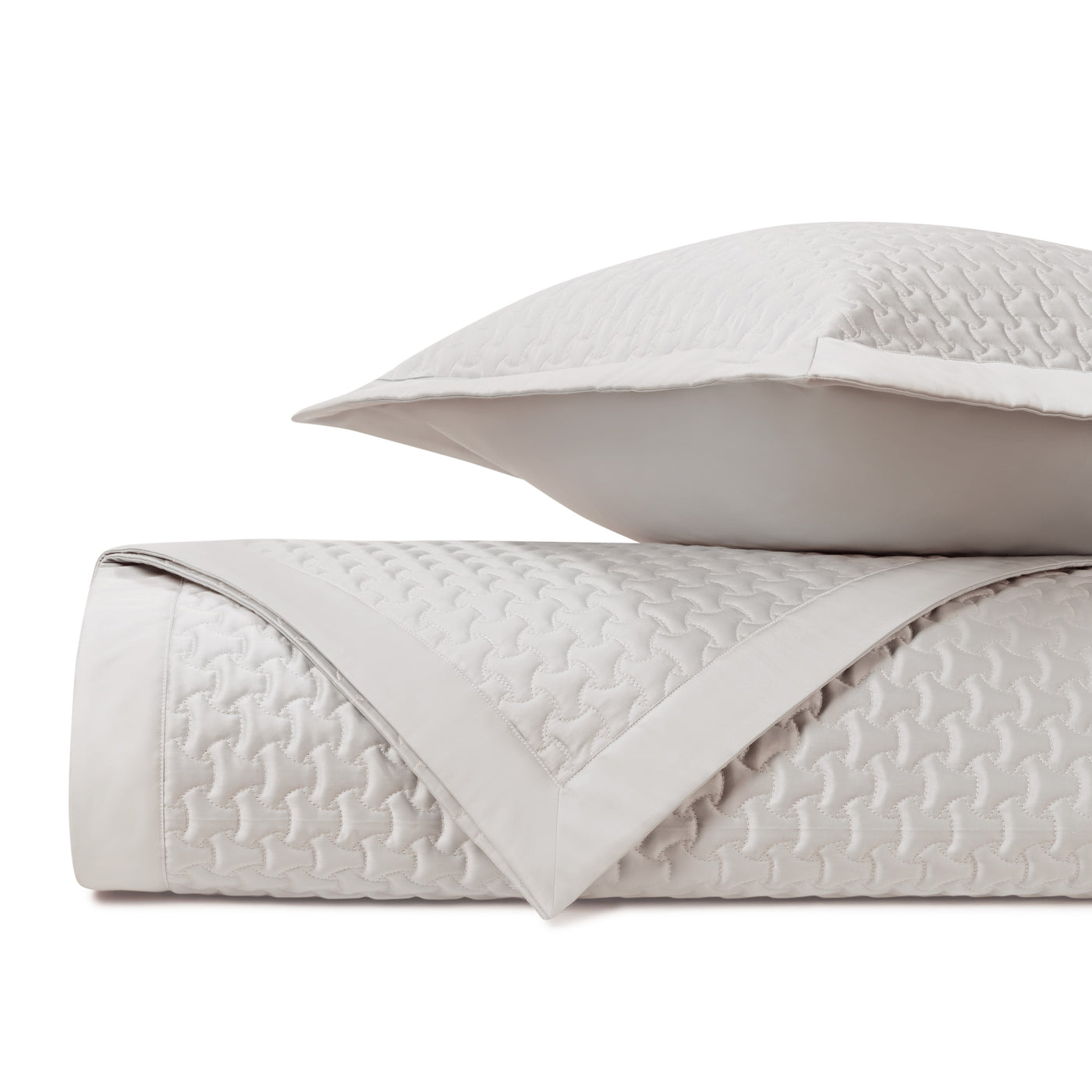 Close-up of Trinity quilted texture in ivory, showing geometric stitched pattern and flat border edge.