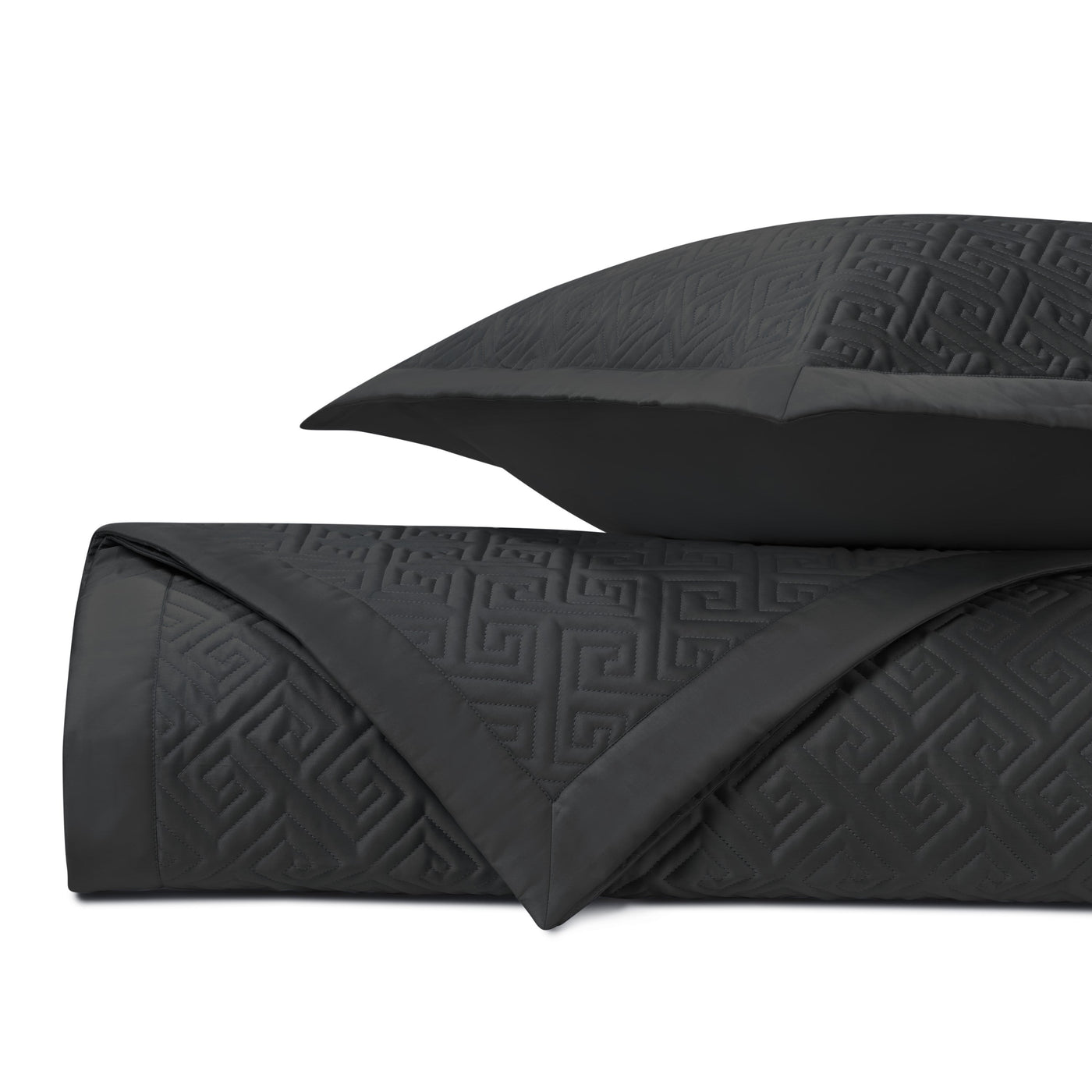 Close-up of black quilted cotton with embossed Greek key pattern.
