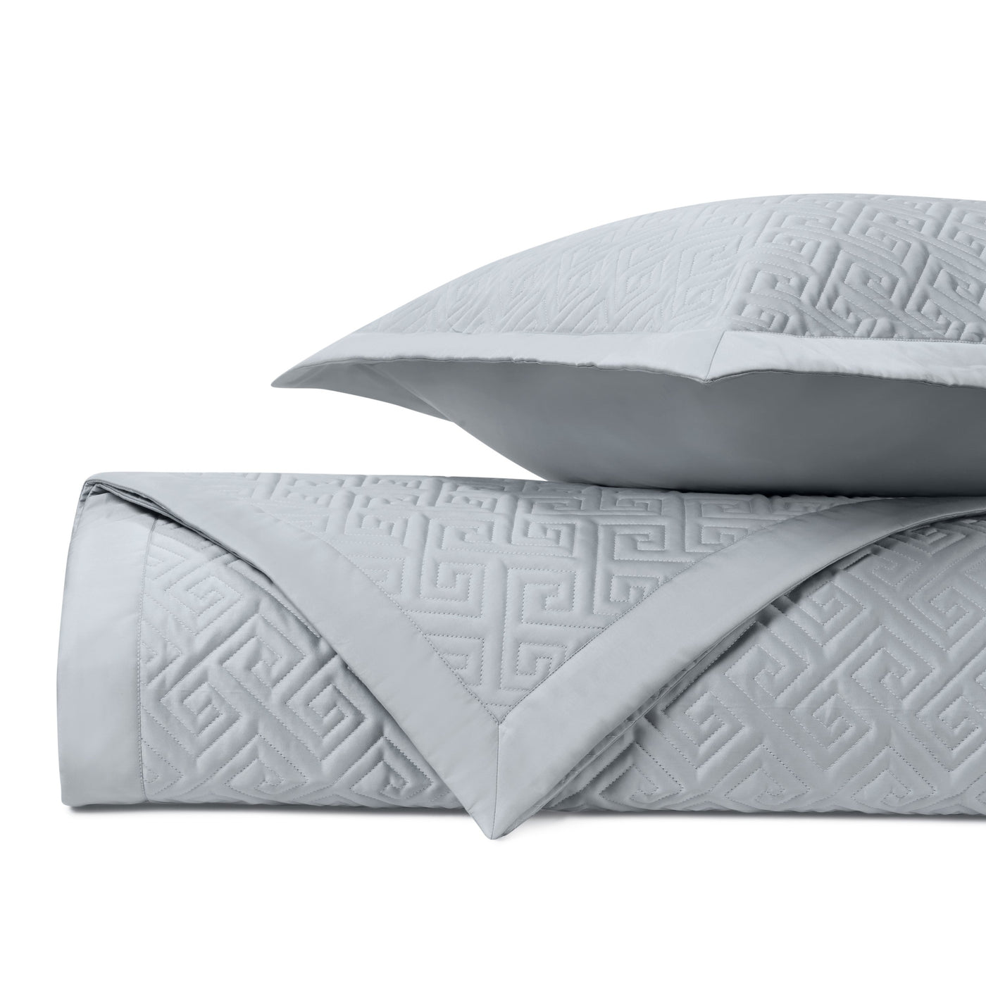 Folded silver quilted coverlet with Greek key pattern and matching euro sham.