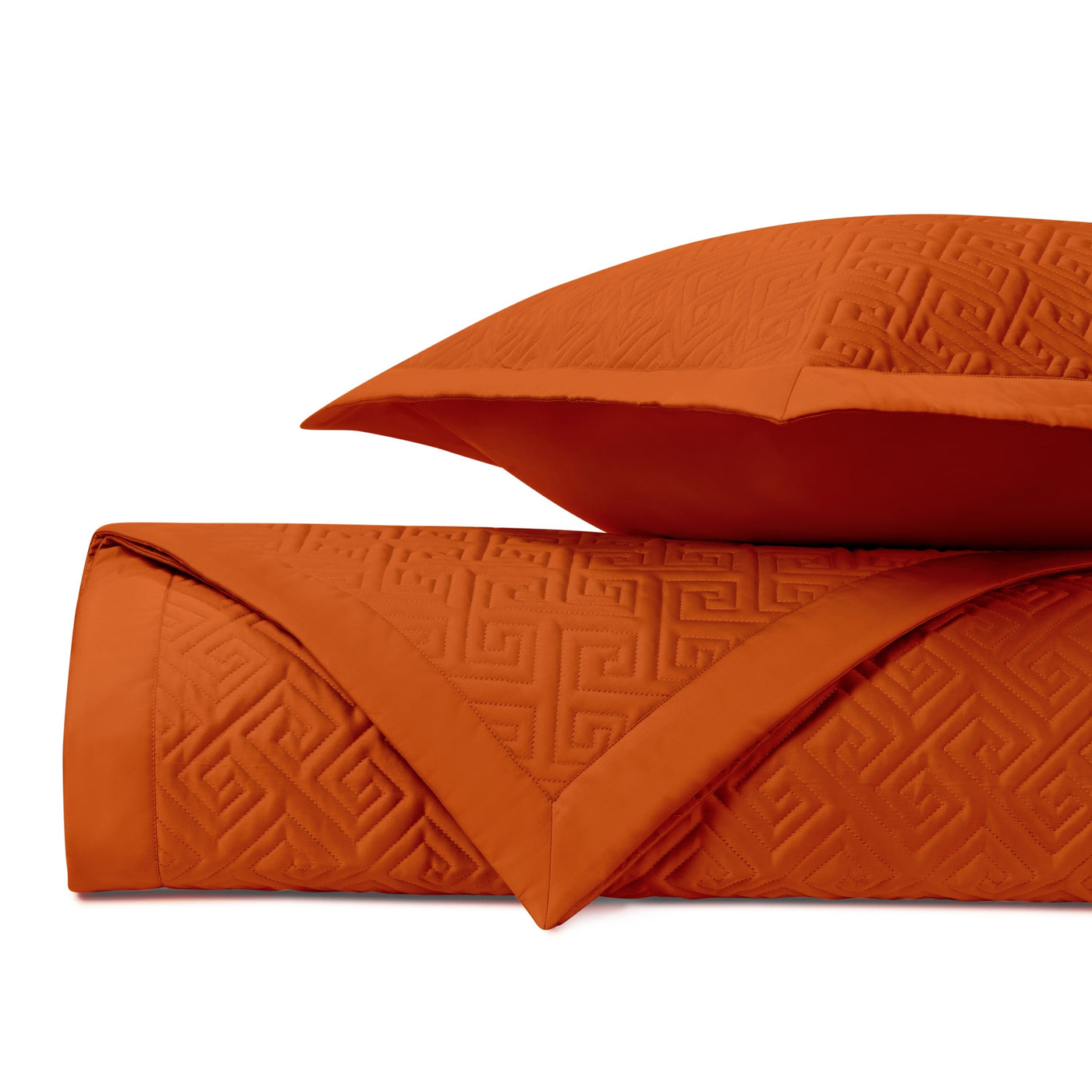 Close-up of Troy quilted fabric in tangerine with tonal Greek key embossed pattern.