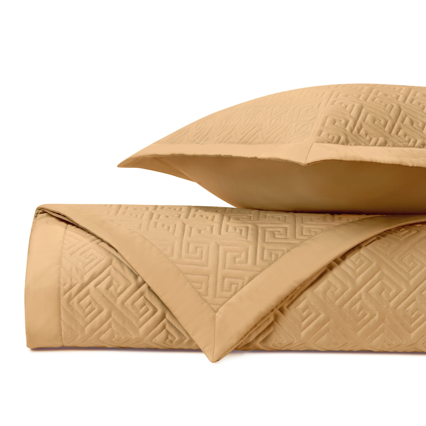 Honey gold quilted coverlet and sham showing embossed Greek key pattern detail.