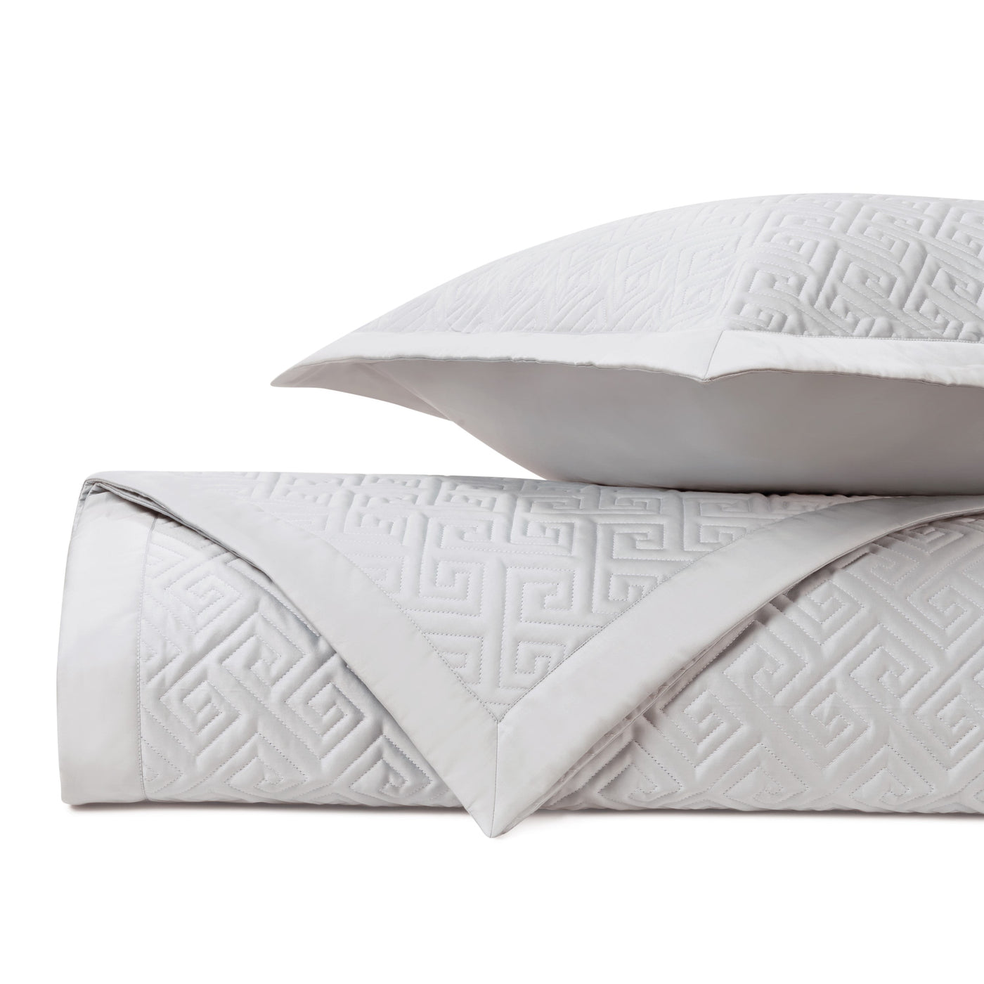Close-up of Home Treasures Troy quilted coverlet in white with embossed Greek key pattern.