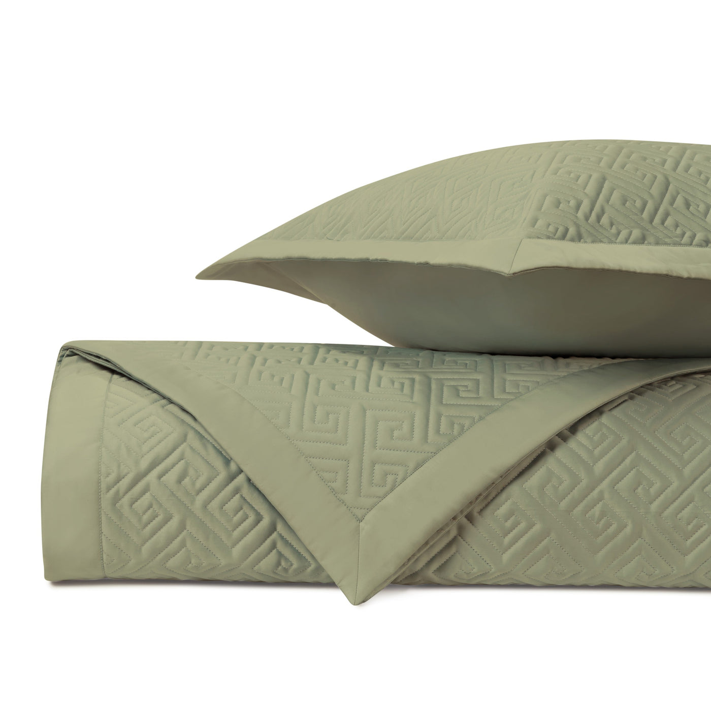 Close-up of sage green quilted coverlet with tonal Greek key pattern, folded with matching euro sham.