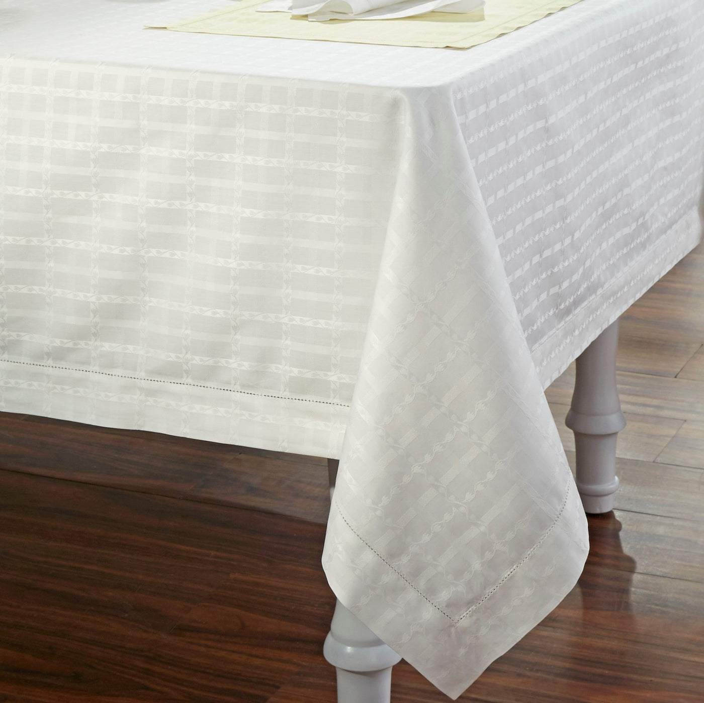 Home Treasures Tulips ivory woven jacquard tablecloth on dining table.