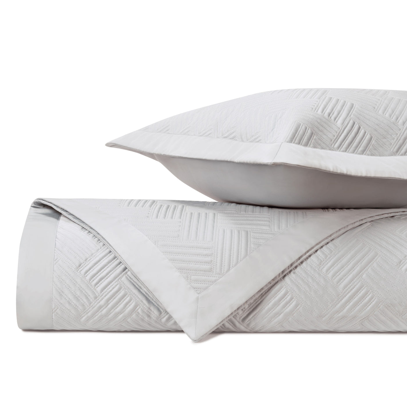 Close-up of ivory quilted cotton with a woven geometric diamond stitch pattern.