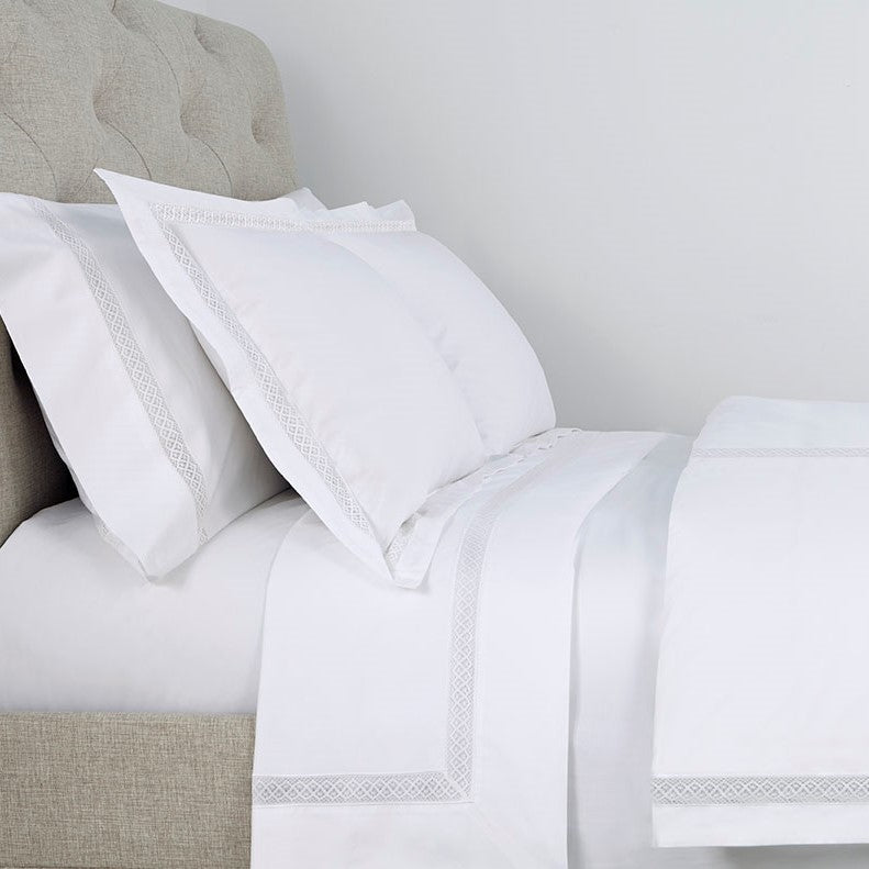 Home Treasures Valencia white cotton bedding with silver embroidered border trim.