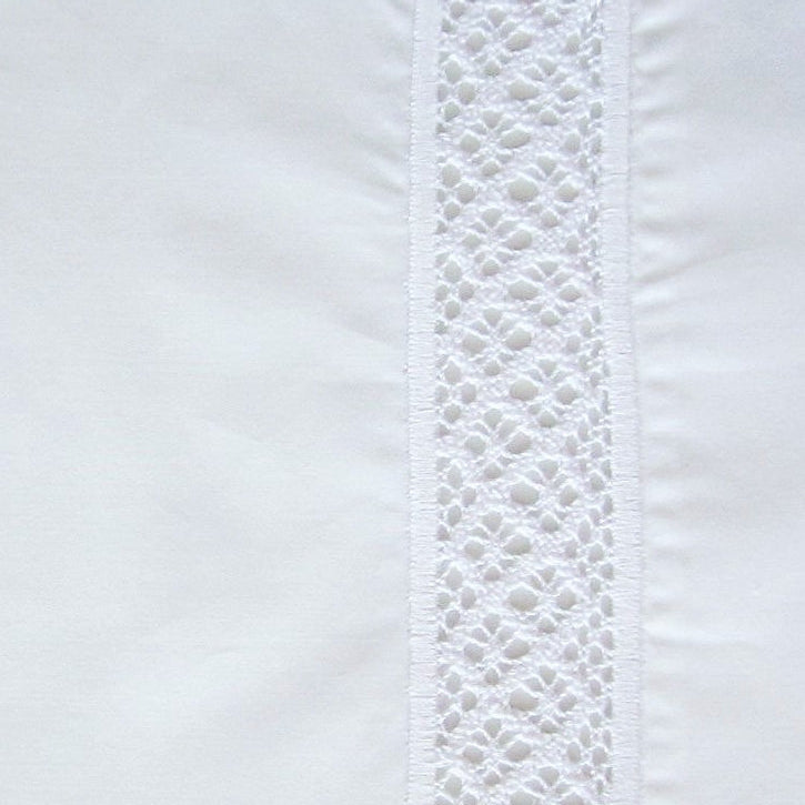 Close-up of white cotton tablecloth with vertical crochet lace trim detail.