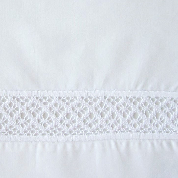 Close-up of white cotton fingertip towel with intricate crochet lace trim band.