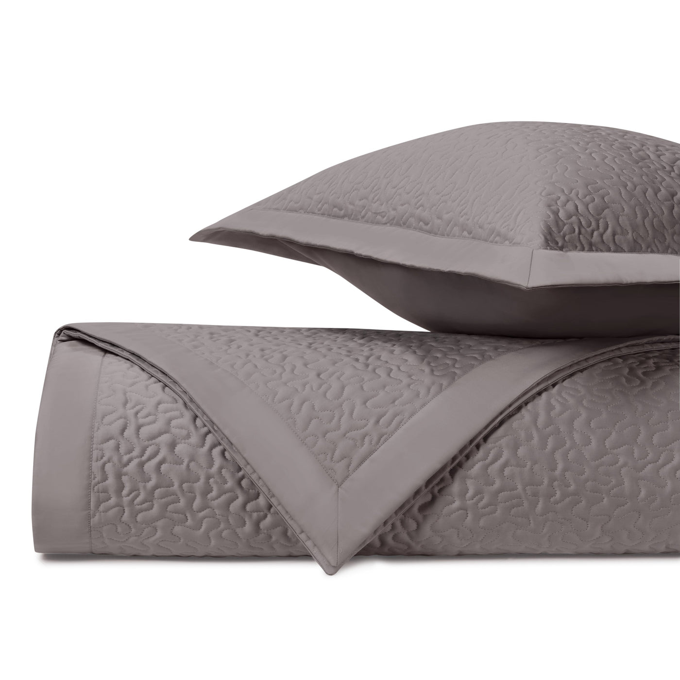 Close-up of taupe quilted texture with vermicelli stitch pattern on coverlet and sham.
