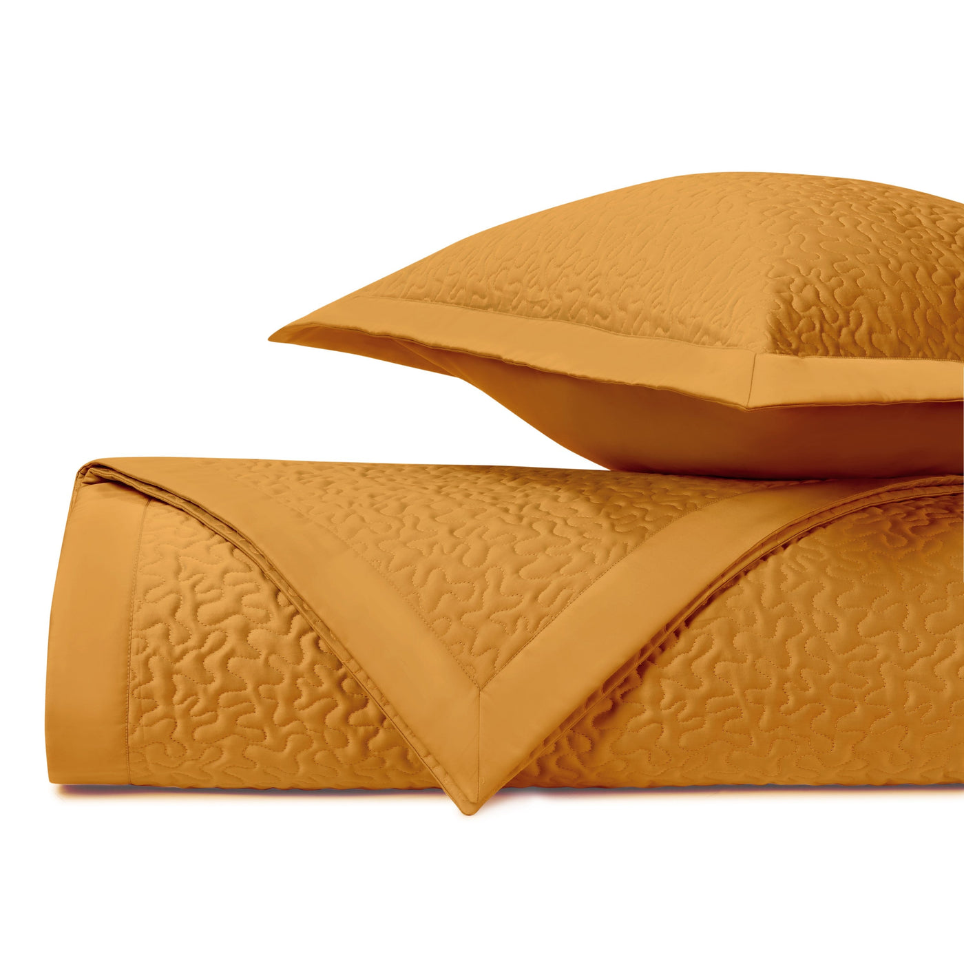 Close-up of saffron quilted coverlet with tone-on-tone vermicelli stitching and sham.