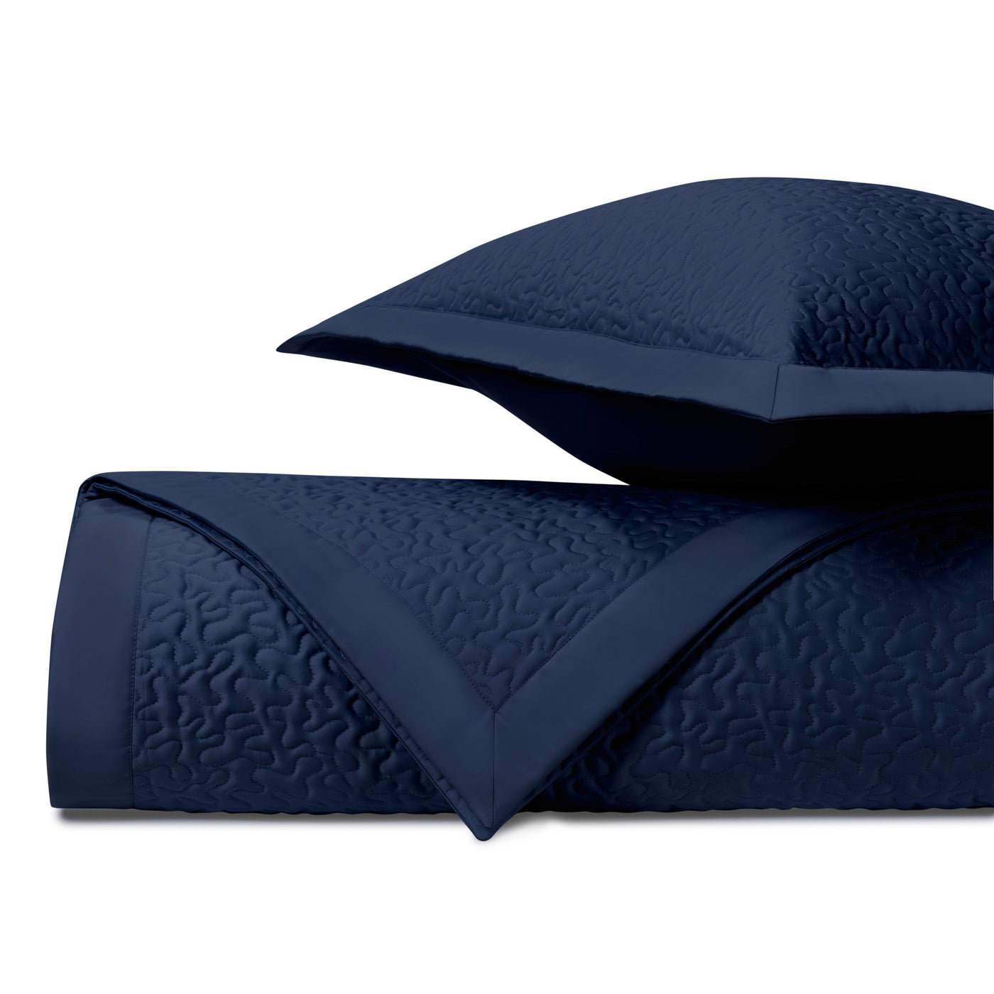Close-up of navy blue quilted coverlet with vermicelli stitching pattern and coordinating sham.