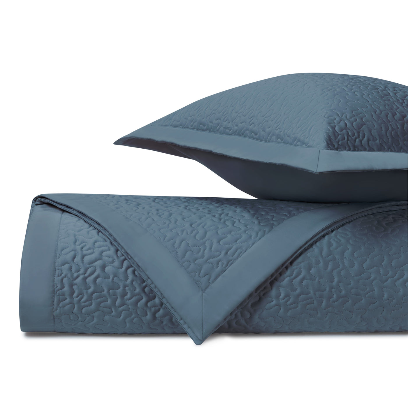 Close-up of Vermicelli quilted texture in slate blue with flange-edge sham detail.