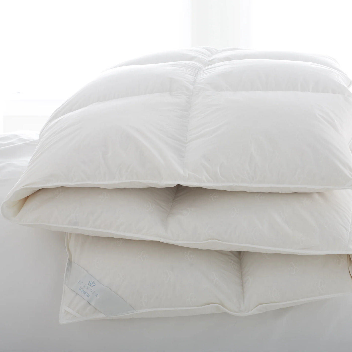 Scandia Home Vienna duvet in ivory, folded and stacked, showing plush down fill and baffle box construction.