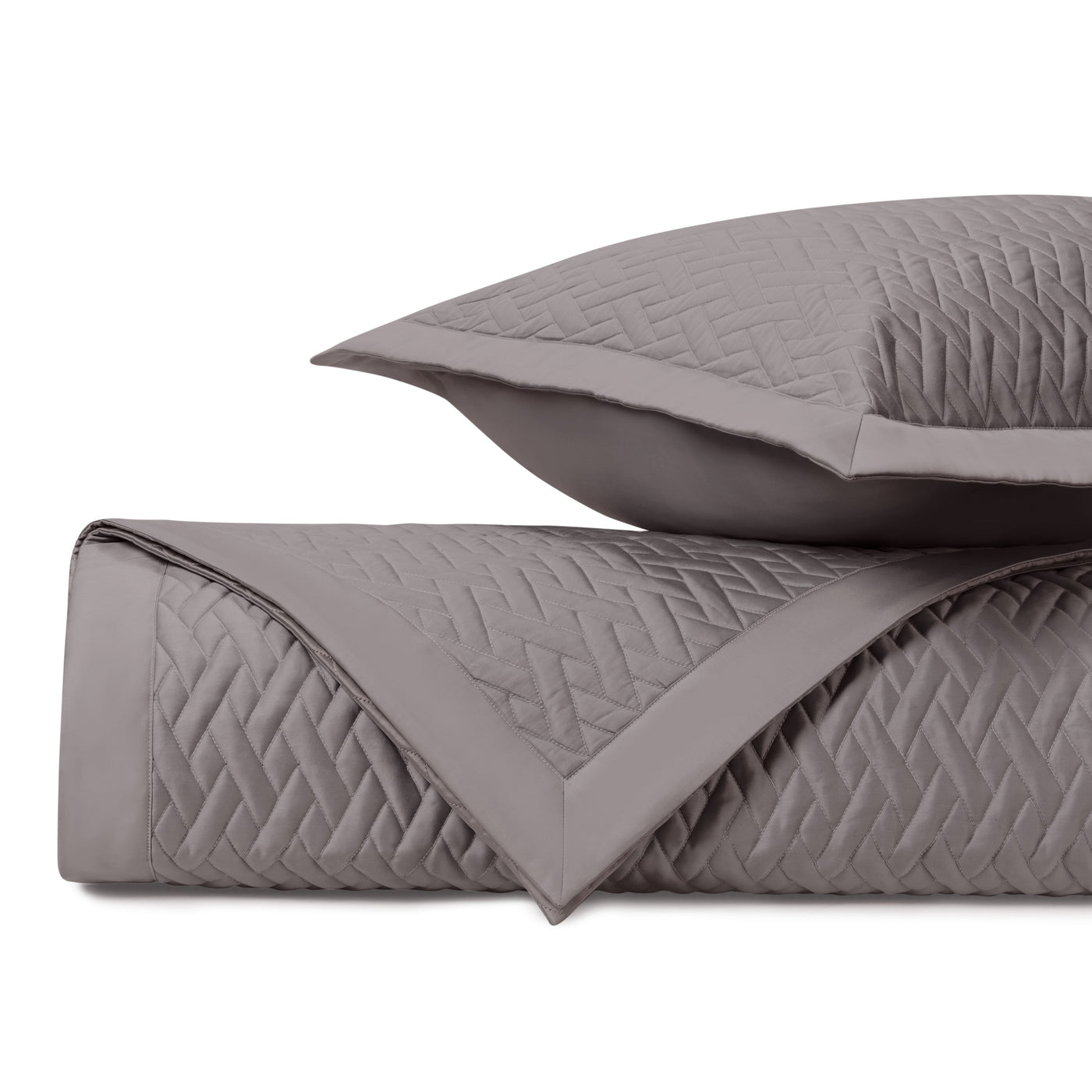 Close-up of Viscaya quilted coverlet in taupe with geometric diamond stitching pattern.