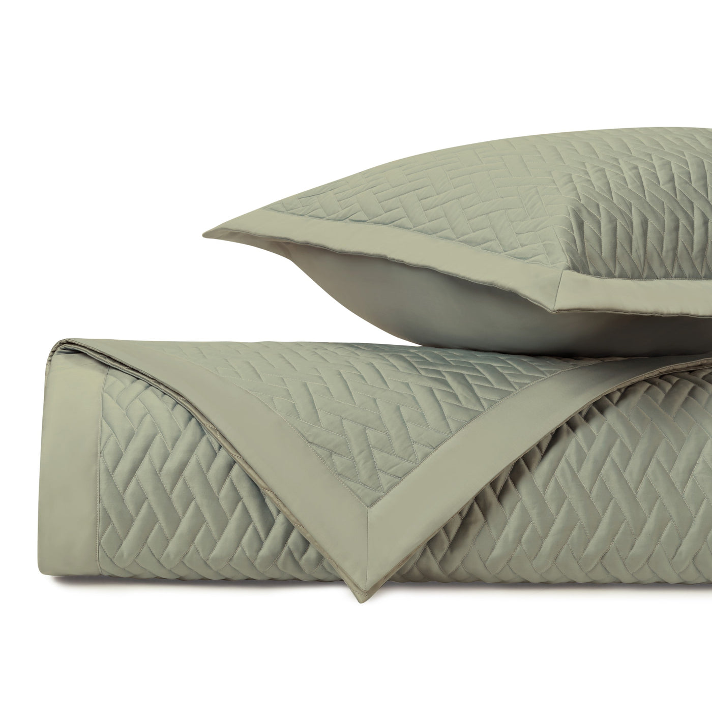 Close-up of sage quilted coverlet and sham showing diamond stitching pattern and border detail.