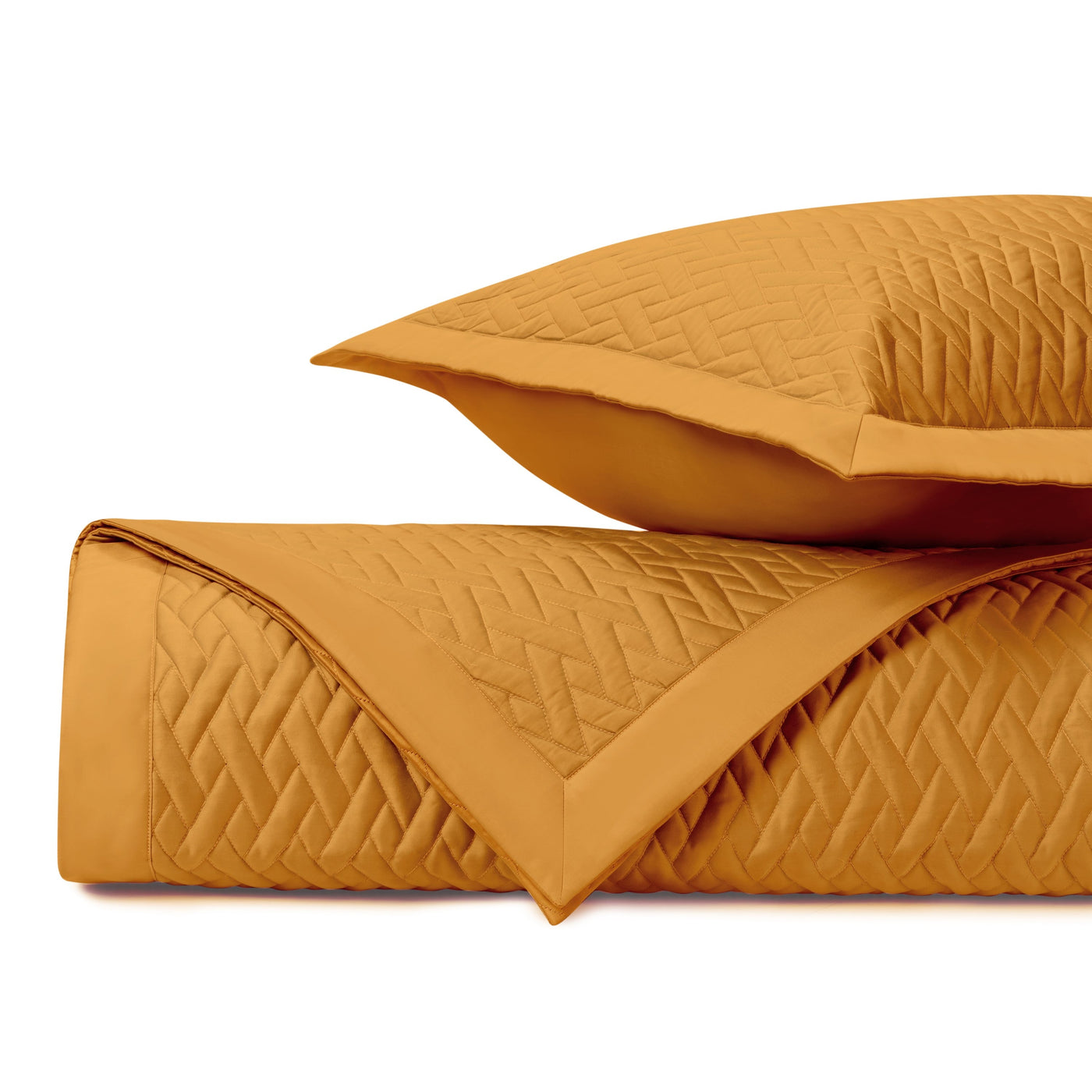 Close-up of saffron quilted coverlet and sham showing diamond weave pattern.