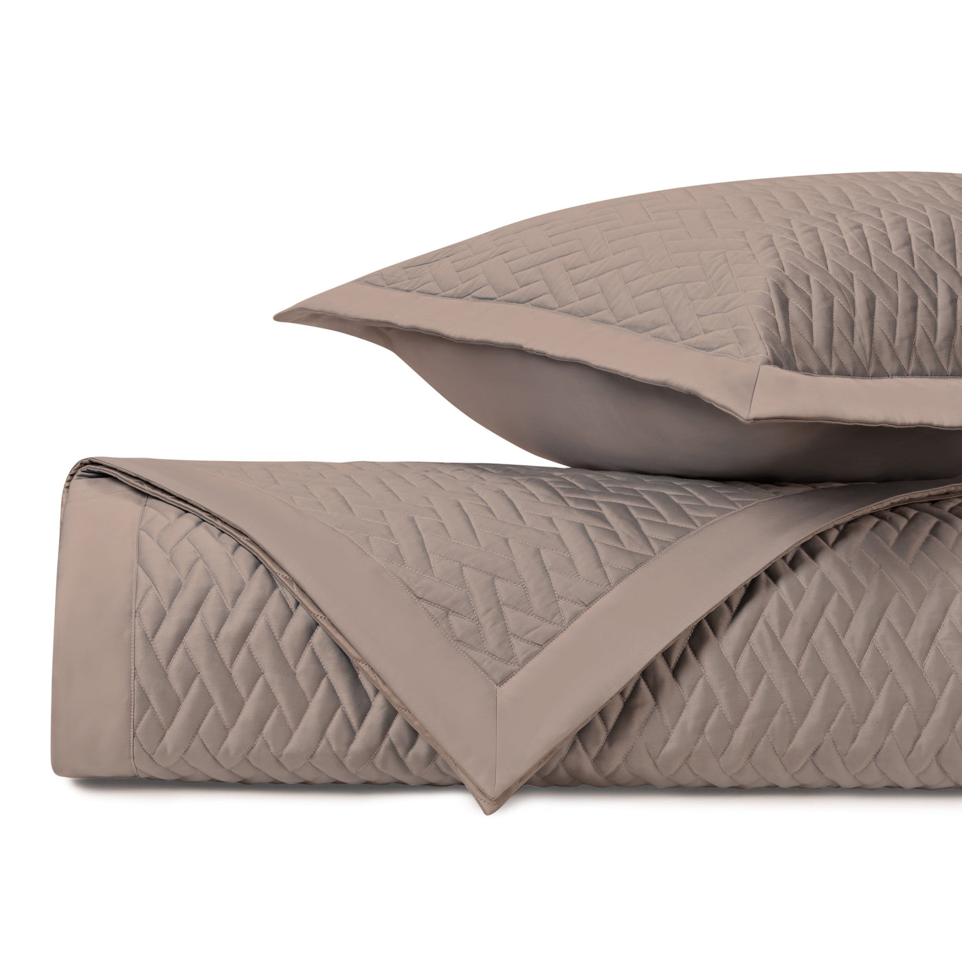 Close-up of taupe quilted coverlet and sham showing diagonal basketweave stitching detail.