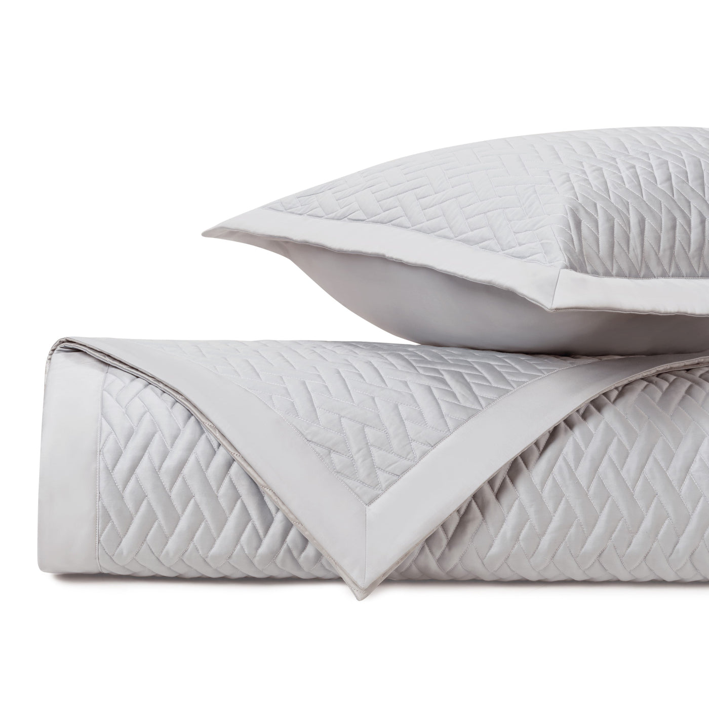 Close-up of folded silver Viscaya quilted coverlet showing geometric diamond stitching pattern.