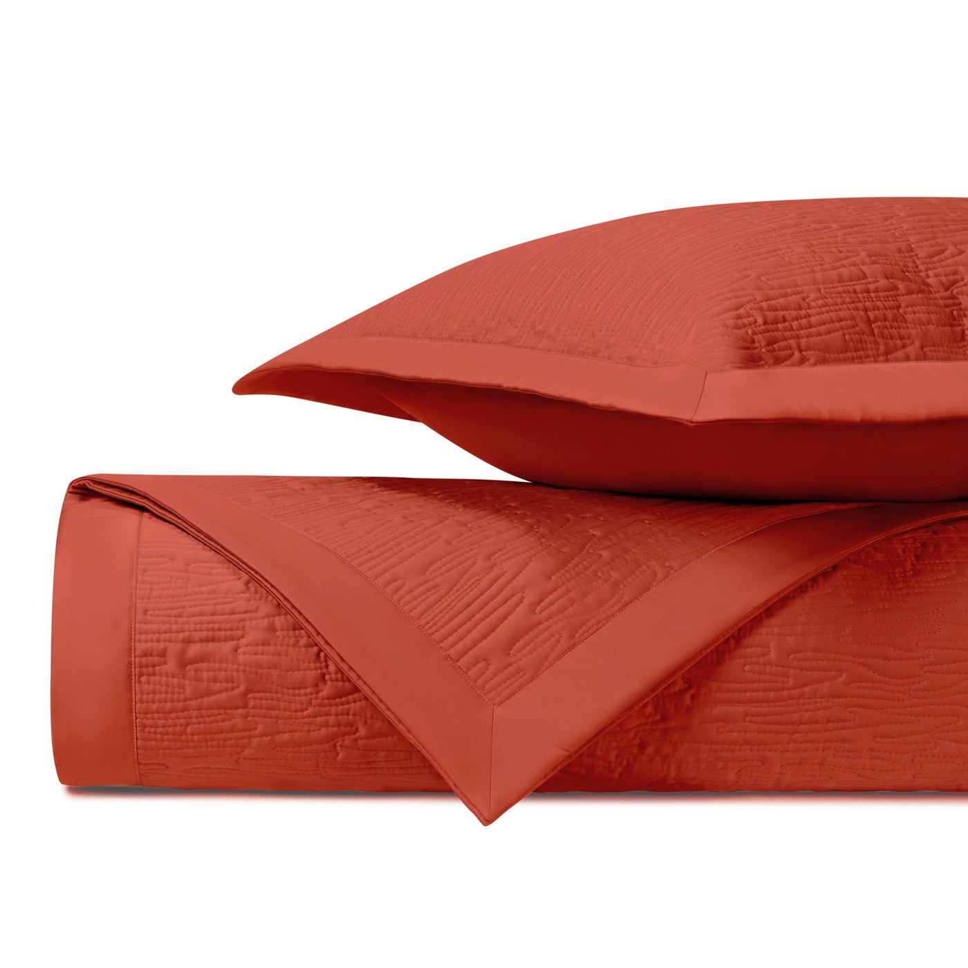 Close-up of Wave quilted yardage in terracotta with textured matelassé weave detail.