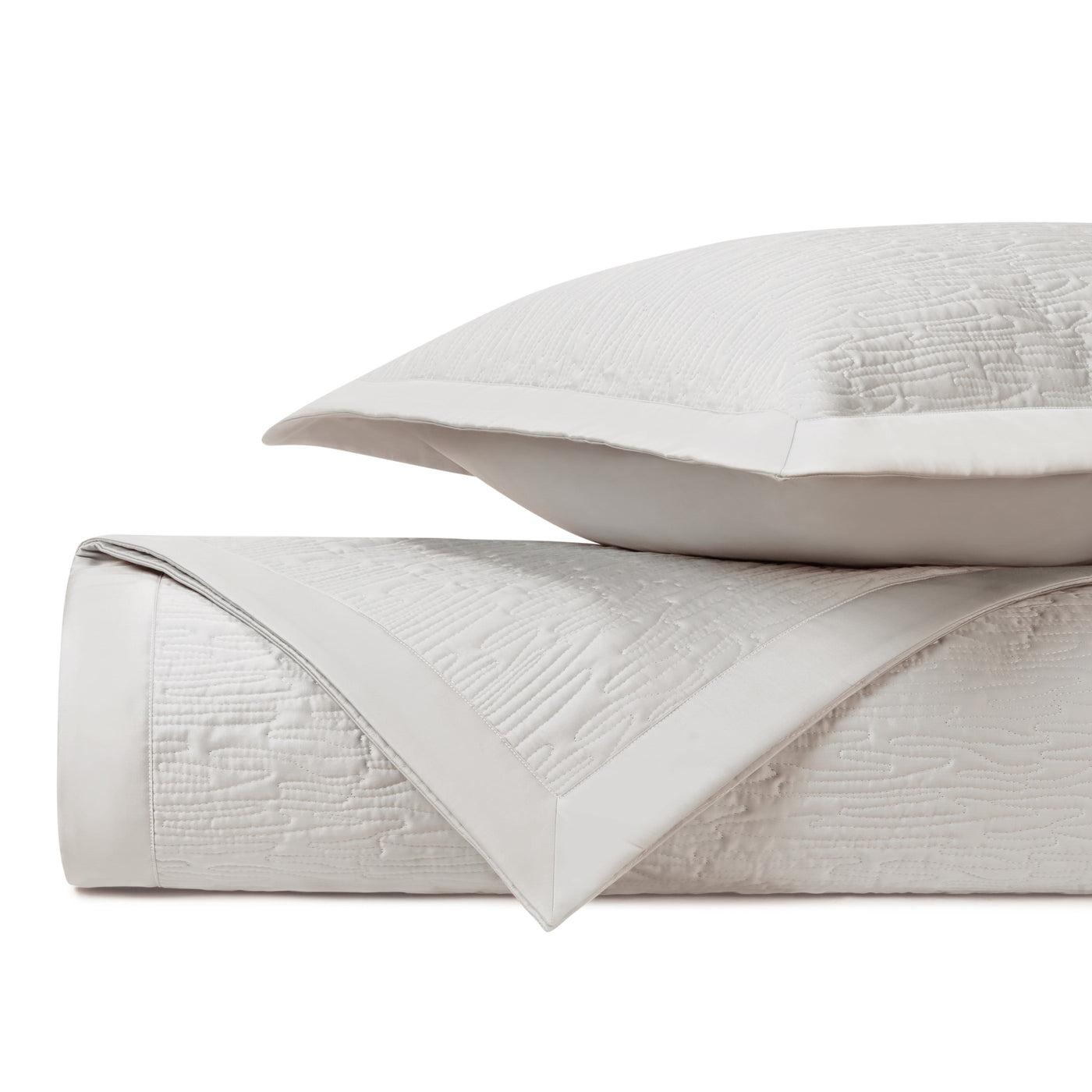 Close-up of Home Treasures Wave quilted coverlet in ivory, showing textured matelassé weave and border detail.