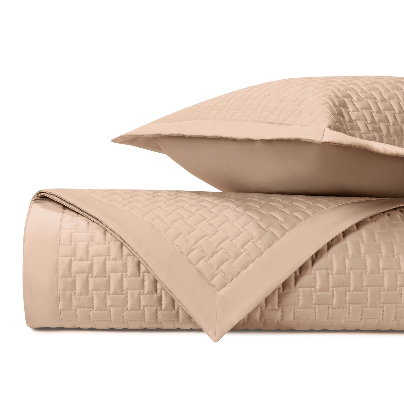 Close-up of basket-weave quilted texture on a blush coverlet with coordinating sham.