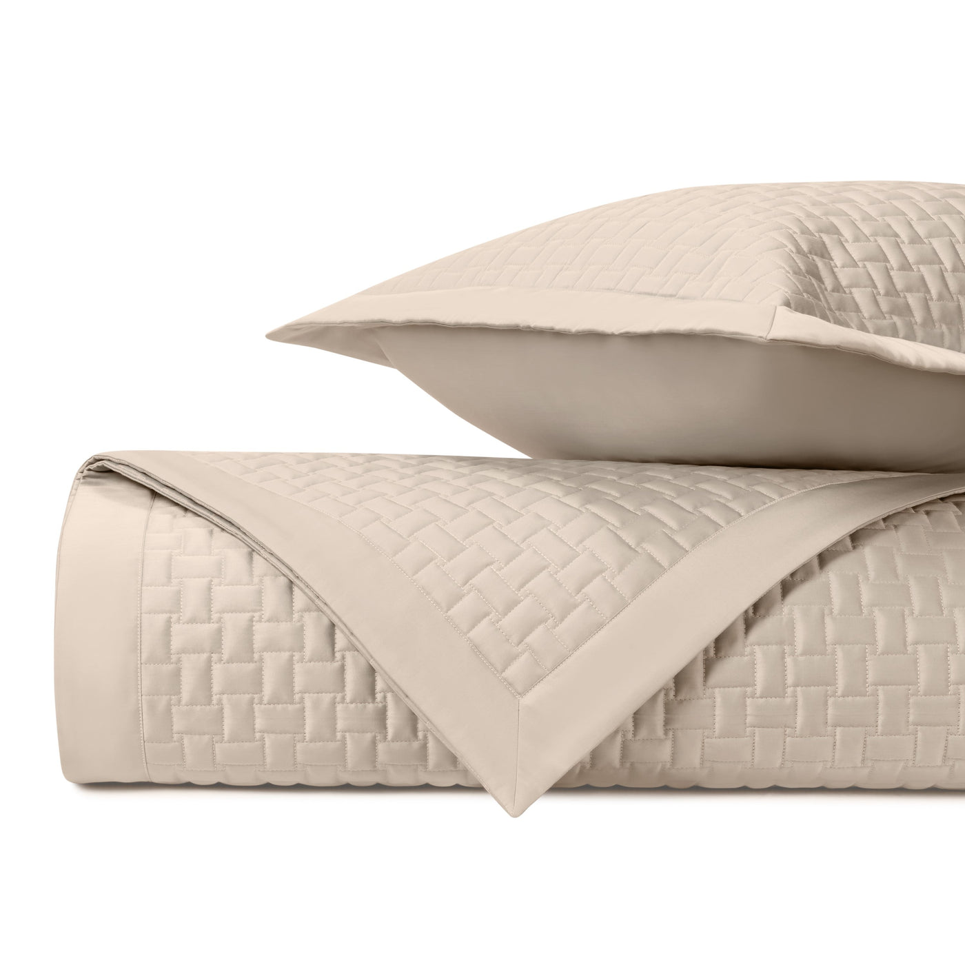 Basketweave quilted texture detail on folded ivory coverlet with coordinating sham.