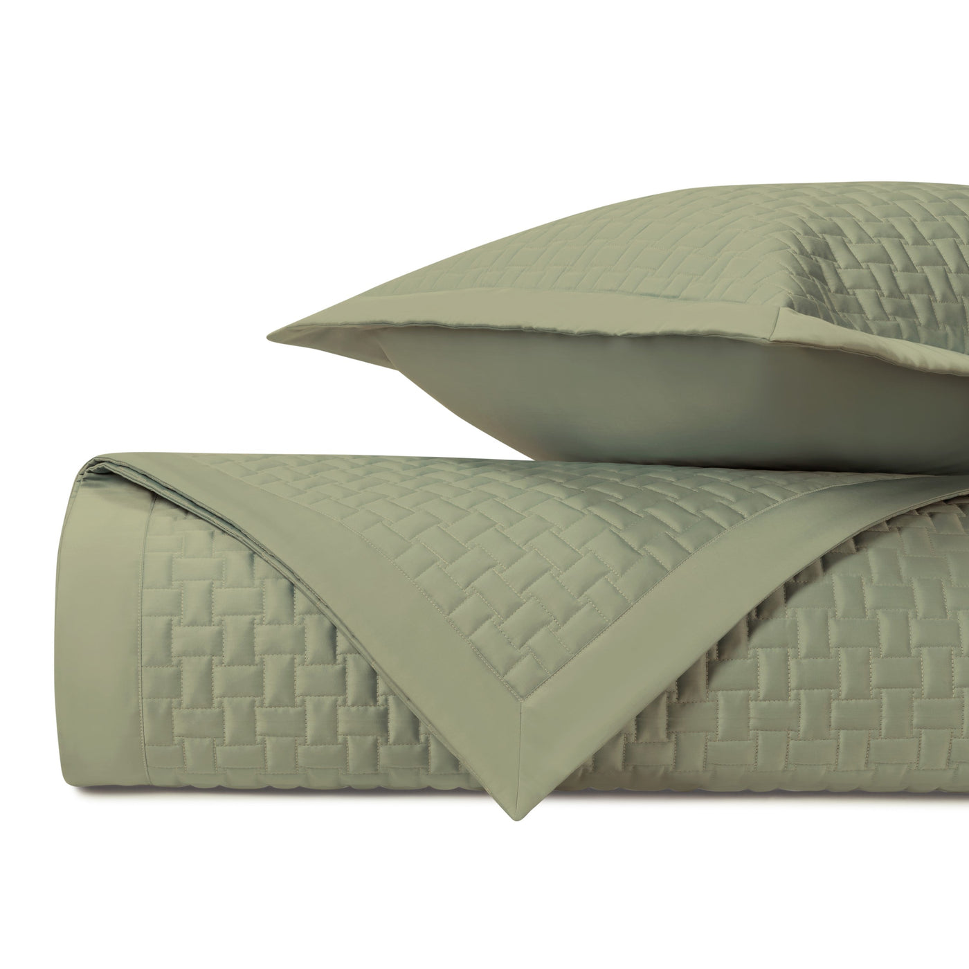 Close-up of sage green quilted coverlet with woven basket-weave texture and coordinating sham.