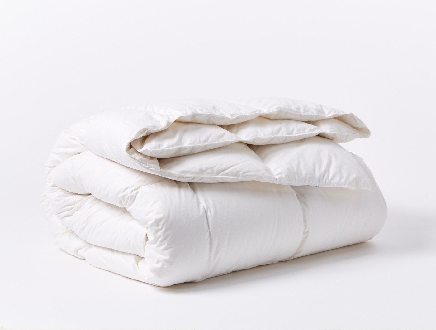 Coyuchi Winter Weight Down duvet insert, white, neatly folded showing plush loft.