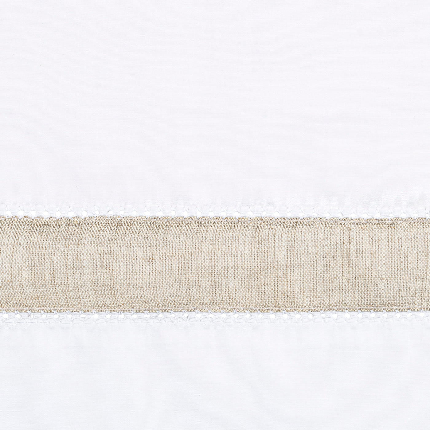 Close-up of a natural linen border band against white fabric.