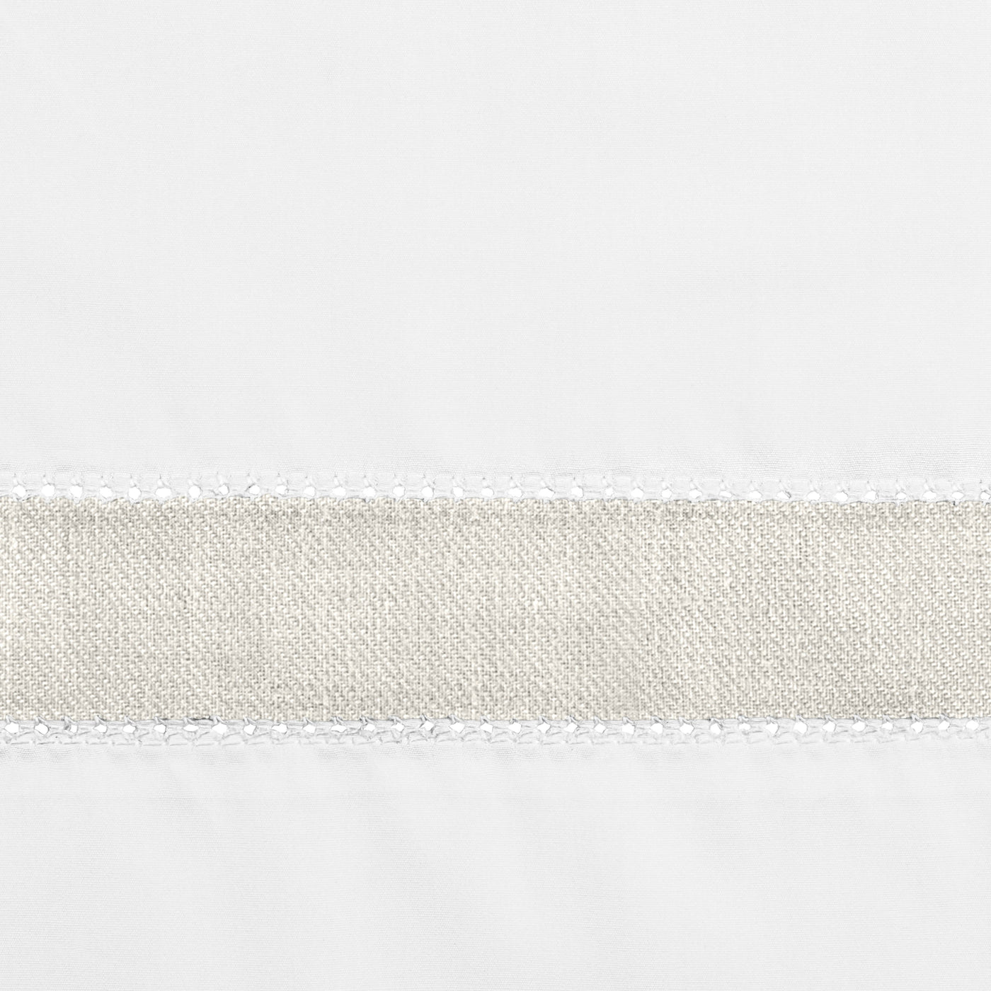 Close-up of Home Treasures Yves linen border trim in natural against white fabric.